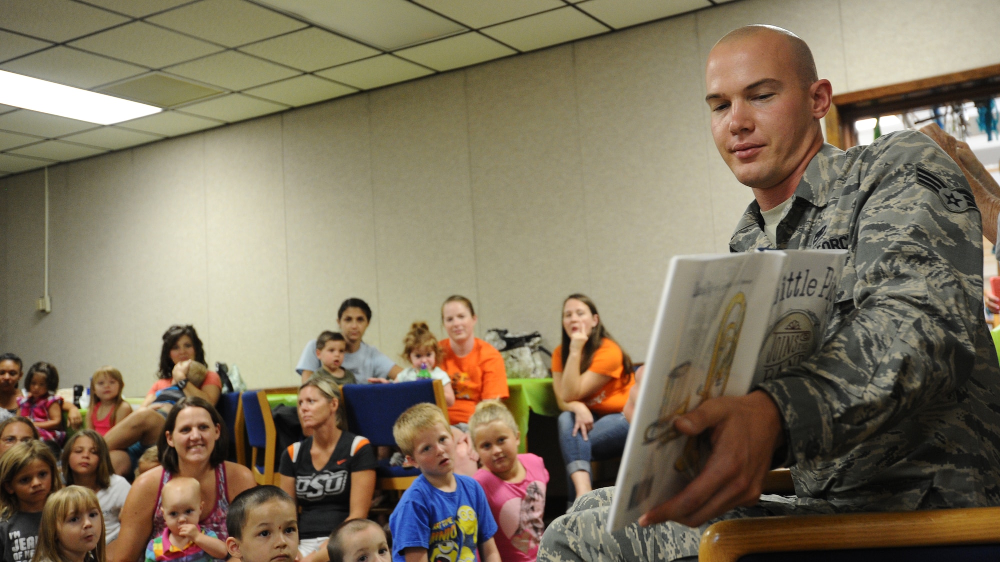 Senior Airman Kristofor Pohl, 325th Maintenance Squadron munitions inspector journeyman, volunteers time to read to children July 8 at the Tyndall Base Library during the Read to the Rhythm program. Read to the Rhythm is a program targeted to develop verbal and reading skills of children sponsored by the 325th Force Support Squadron. (U.S. Air Force photo by Senior Airman Ty-Rico Lea/Released)