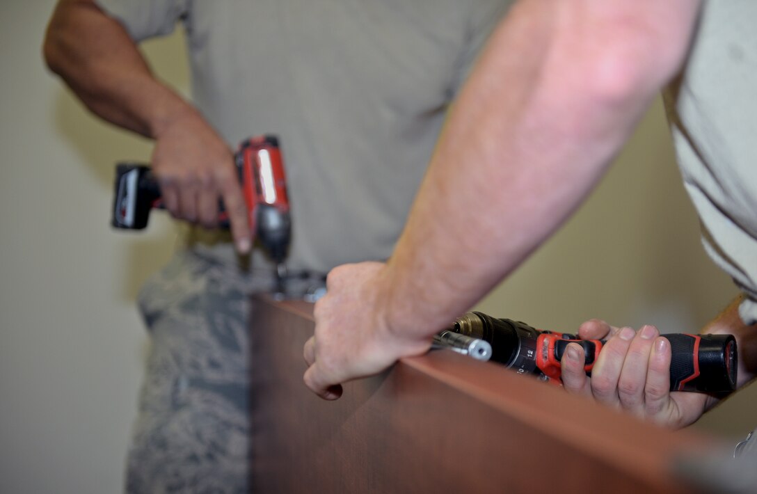 Airmen from the 22nd Civil Engineer Squadron screw hinges on a door Aug. 11, 2015, at McConnell Air Force Base, Kan. The doors were installed in Bldg. 1219, which is set to become the new alert facility. (U.S. Air Force photo by Senior Airman Colby L. Hardin)
