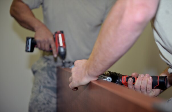 Airmen from the 22nd Civil Engineer Squadron screw hinges on a door Aug. 11, 2015, at McConnell Air Force Base, Kan. The doors were installed in Bldg. 1219, which is set to become the new alert facility. (U.S. Air Force photo by Senior Airman Colby L. Hardin)
