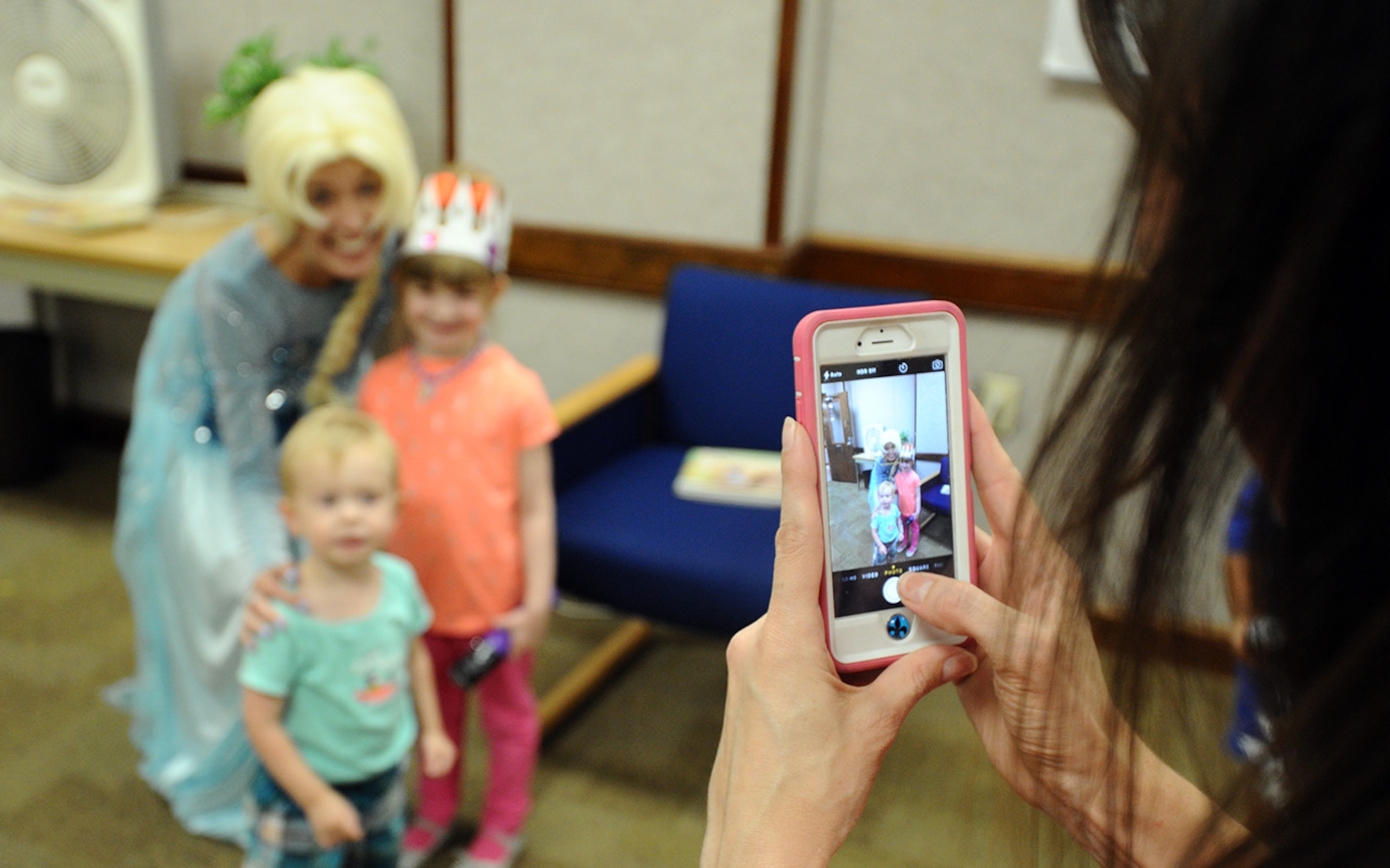 Julianne Saratsis, military spouse, poses for a photo with children while dressed as Elsa from the movie Frozen July 8 at the Tyndall Base Library during the Read to the Rhythm program July 8. Read to the Rhythm is a program targeted to develop verbal and reading skills of children sponsored by the 325th Force Support Squadron. (U.S. Air Force photo by Senior Airman Ty-Rico Lea/Released)
