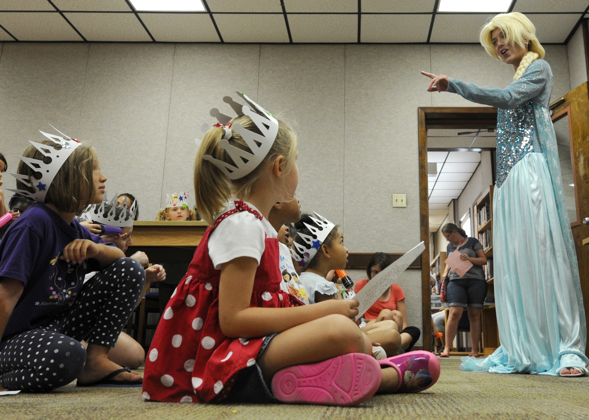 Julianne Saratsis, military spouse, performs a musical number dressed as Elsa from the movie Frozen July 8 at the Tyndall Base Library during the Read to the Rhythm program July 8. Read to the Rhythm is a program targeted to develop verbal and reading skills of children sponsored by the 325th Force Support Squadron. (U.S. Air Force photo by Senior Airman Ty-Rico Lea/Released)