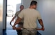 Staff Sgt. Calvin Myers, left, and Tech. Sgt. Luis Garcia-Alvarez, 22nd Civil Engineer Squadron structural craftsmen, bring in a door from outside into Bldg. 1219 before installing it Aug. 11, 2015, at McConnell Air Force Base, Kan. Bldg. 1219 will become the new alert facility and features sleeping quarters. (U.S. Air Force photo by Senior Airman Colby L. Hardin)