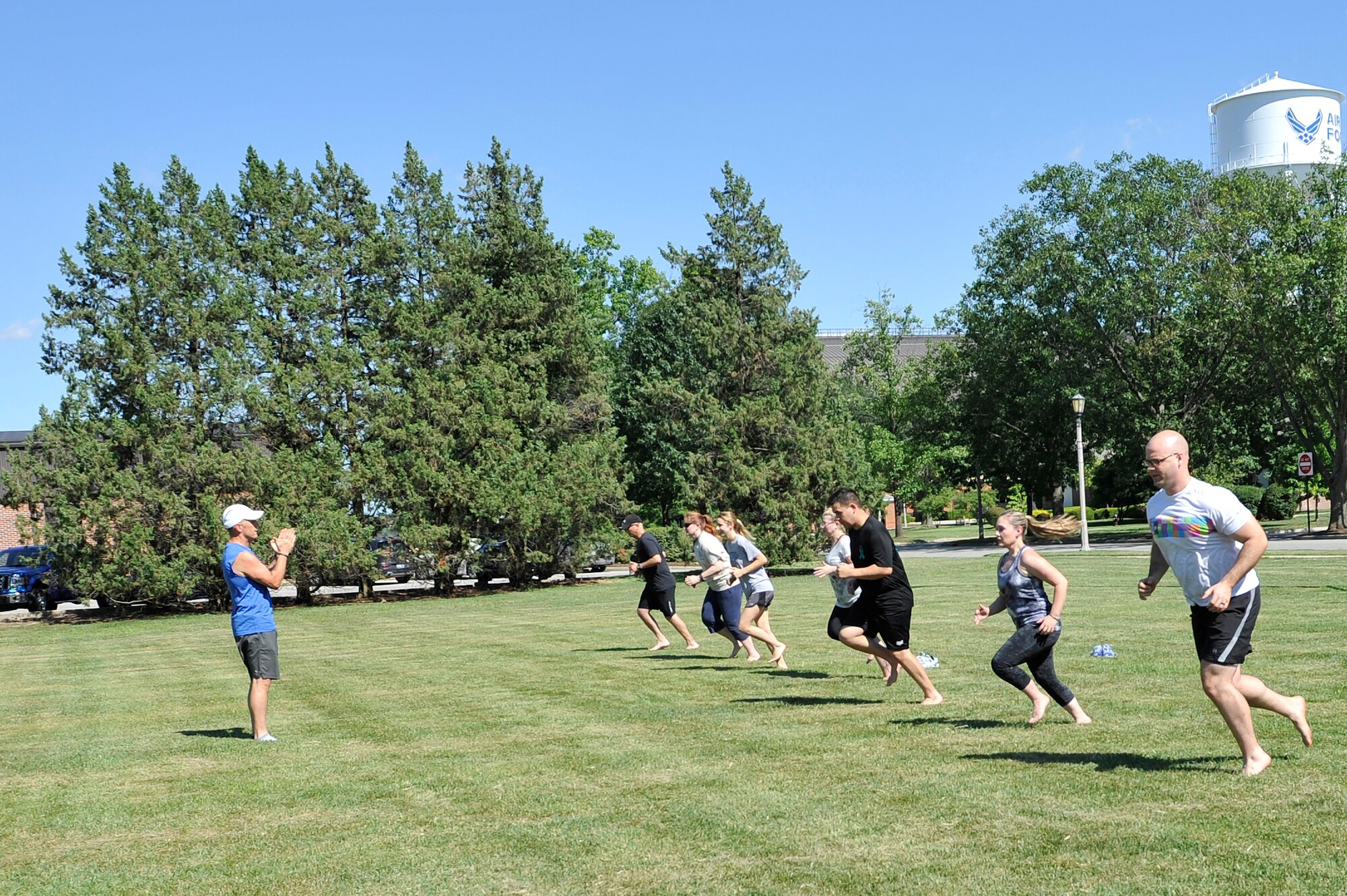 Al Bromley, 375th Aerospace Medicine Squadron Health Promotions Flight, leads a group of runners in an exercise aiming to correct running problems during a pain free running clinic on July 31, 2015 at Scott Air Force Base, Illinois. The clinic helps runners to correct their running style, aiming to help them to run with less pain. (U.S. Air Force photo by Senior Airman Sarah Hall-Kirchner/released)