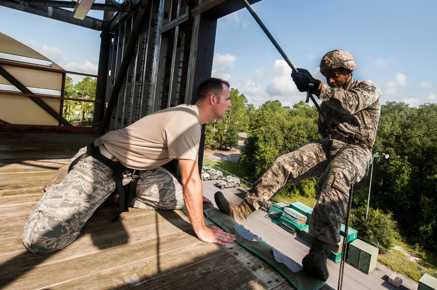 U.S. Air Force Staff Sgt. Daniel Centreras, 822d Base Defense Squadron fire team leader, awaits confirmation from Staff Sgt. Michael Kearns, 820th Base Defense Group rappel master, to rappel Aug. 5, 2015. Centreras and five other base defenders took part in rappel training to enhance their capabilities. (U.S. Air Force photo by Airman 1st Class Dillian Bamman/Released)