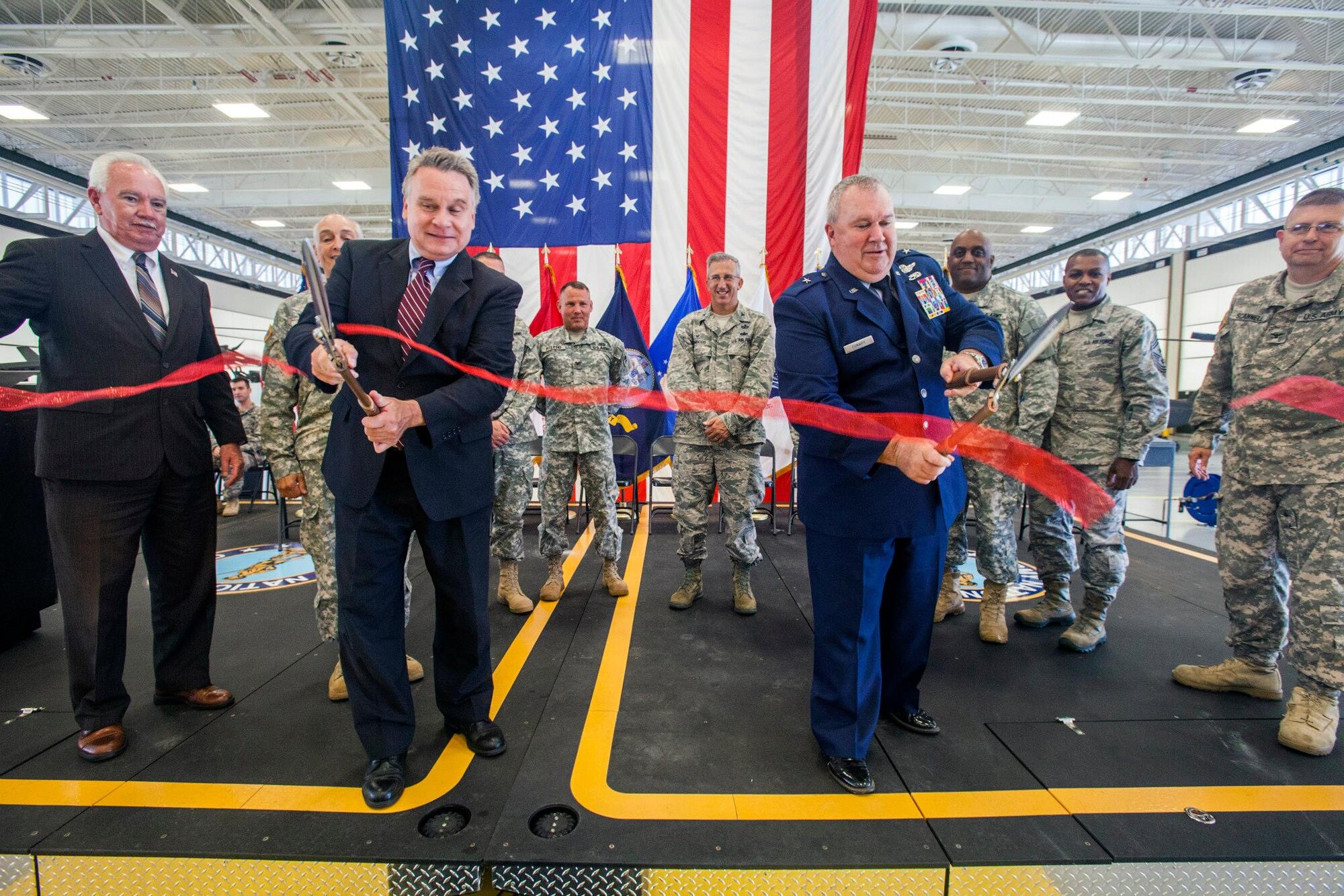 U.S. Rep. Christopher Smith, second from left, (R-4th Dist.) and Brig. Gen. Michael L. Cunniff, fourth from right, 108th Wing commander, cut the ribbon during the ceremony at the New Jersey Army National Guard's Army Aviation Support Facility, located at Joint Base McGuire-Dix-Lakehurst, N.J., Aug. 11, 2015. The 103,602 square-foot facility enhances the New Jersey National Guard's response to state and federal missions by providing the newest and most efficient aircraft maintenance and training support equipment. The facility includes 10 aircraft maintenance hangar bays, two unheated storage buildings and allied shops. (U.S. Air National Guard photo by Master Sgt. Mark C. Olsen/Released)