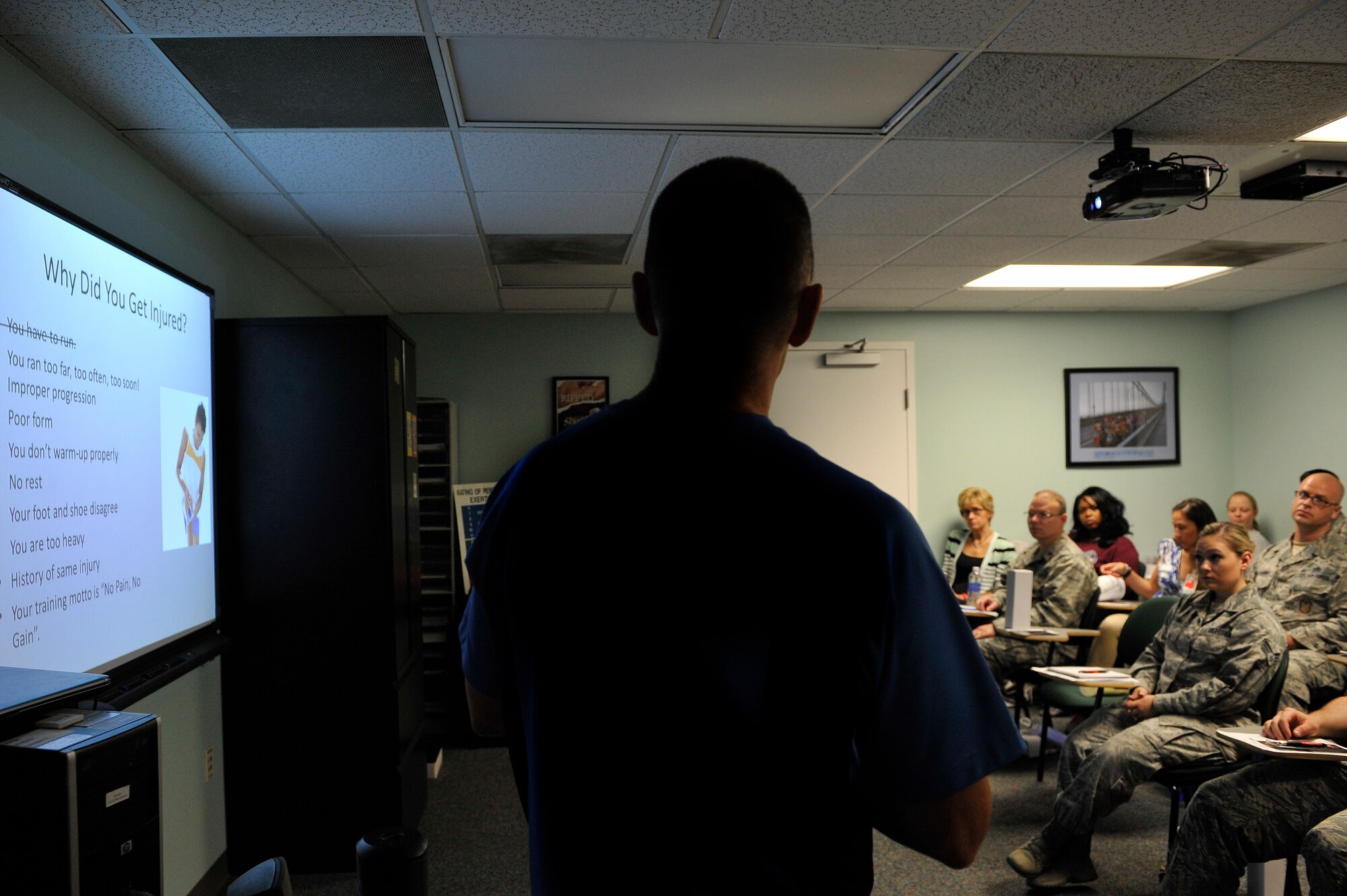 Al Bromley, 375th Aerospace Medicine Squadron Health Promotions Flight, explains why runners experience so many injuries over time on July 31, 2015 during a pain free running clinic at Scott Air Force Base, Illinois. The clinic helps runners to correct their running style, aiming to help them to run with less pain. (U.S. Air Force photo by Senior Airman Sarah Hall-Kirchner/released)