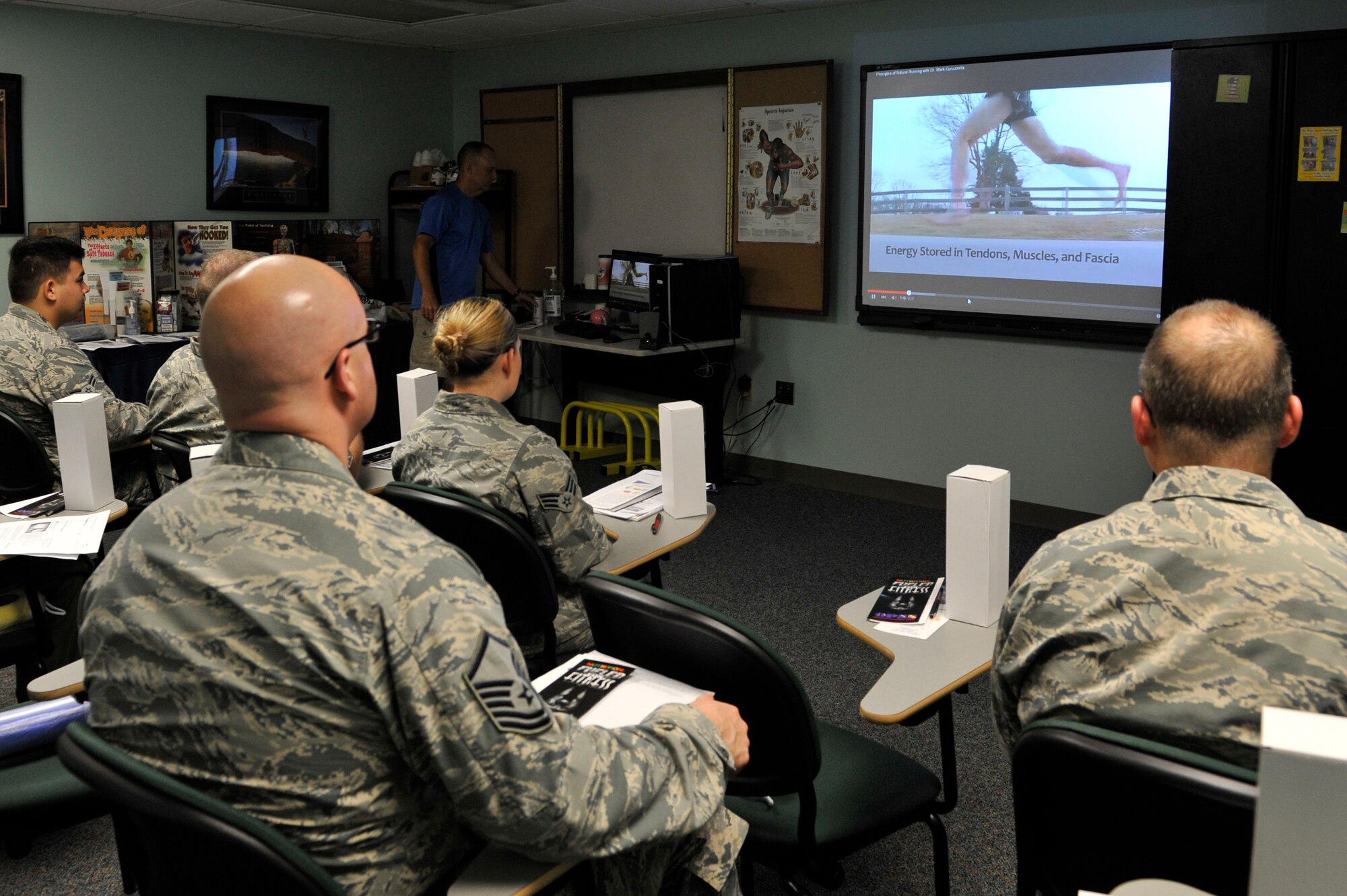 Members of Team Scott watch a video about running posture on July 31, 2015 during a pain free running clinic at Scott Air Force Base, Illinois. The clinic helps runners to correct their running style, aiming to help them to run with less pain. (U.S. Air Force photo by Senior Airman Sarah Hall-Kirchner/released)