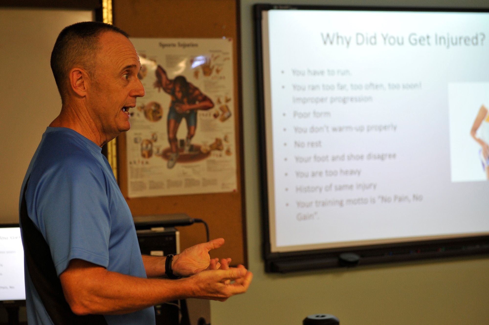 Al Bromley, 375th Aerospace Medicine Squadron Health Promotions Flight, explains why runners experience so many injuries over time on July 31, 2015 during a pain free running clinic at Scott Air Force Base, Illinois. The clinic helps runners to correct their running style, aiming to help them to run with less pain. (U.S. Air Force photo by Senior Airman Sarah Hall-Kirchner/released)
