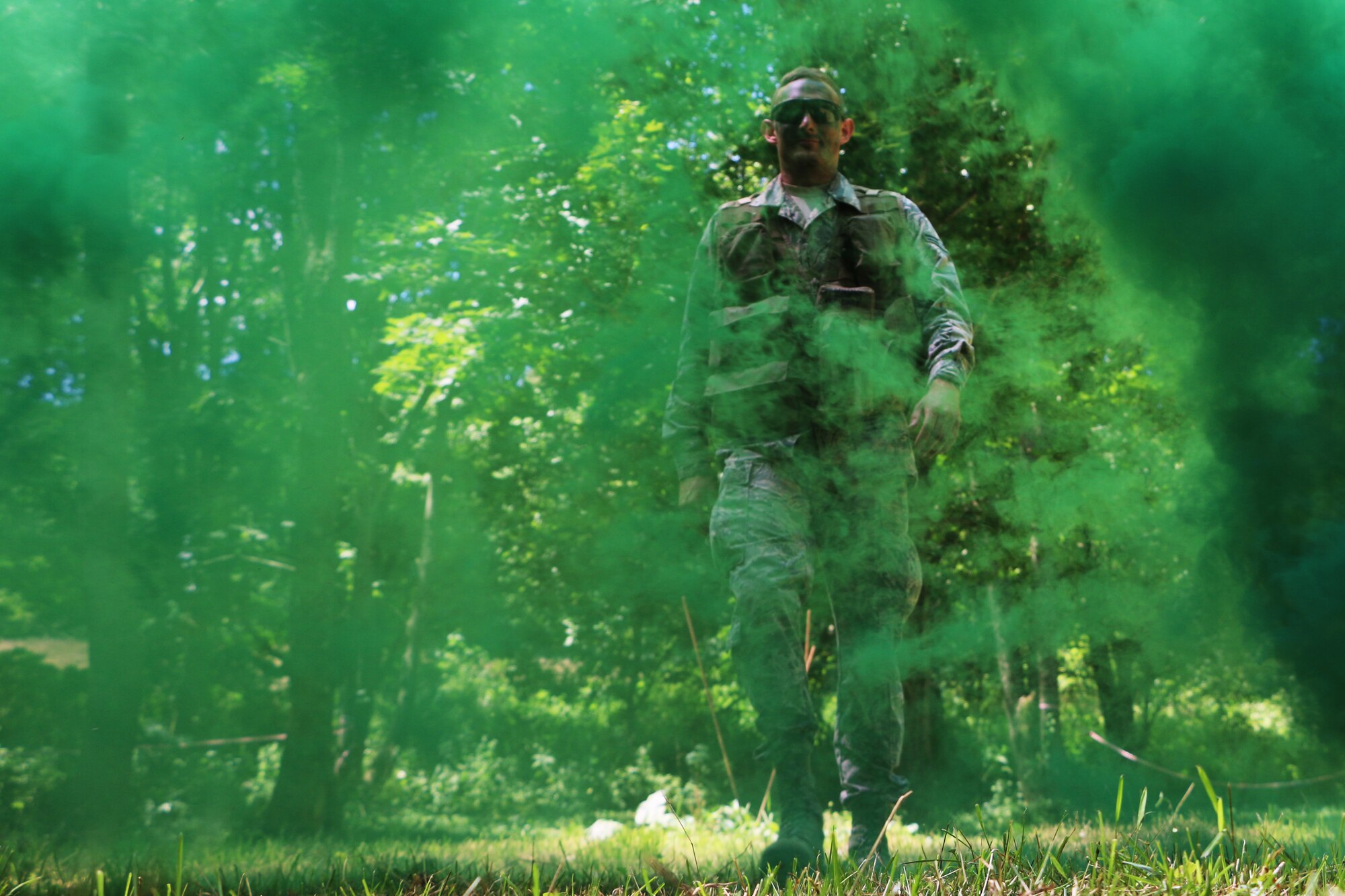 Airman 1st Class Josh Ensman walks through the signal smoke as members of the 164th Airlift Squadron train on evasion during ground survival training near Butler, Ohio, Aug. 1, 2014. The 113th Air Support Operations Squadron (ASOS), of the 181st Intelligence Wing, Terre Haute, IN., assisted the Ohio Air Guard aircrew with the training. Two members of the 113th ASOS Tactical Air Patrol Party (TACP) teamed up to share their expertise in this training. The aircrew members are required to stay current in survival tactics and procedures on both land and water.(U.S. Air National Guard Photo by Tech. Sgt. Joseph Harwood\Released)