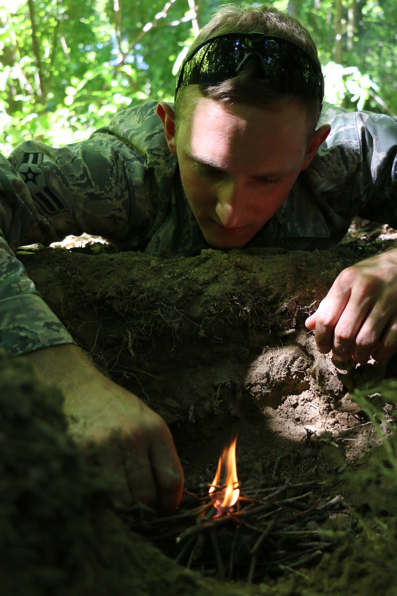 Airman 1st Class Josh Ensman works on starting a survival fire as members of the 164th Airlift Squadron perform ground survival training near Butler, Ohio, Aug. 1, 2014. The 113th Air Support Operations Squadron (ASOS), of the 181st Intelligence Wing, Terre Haute, IN., assisted the Ohio Air Guard aircrew with the training. Two members of the 113th ASOS Tactical Air Patrol Party (TACP) teamed up to share their expertise in this training. The aircrew members are required to stay current in survival tactics and procedures on both land and water.(U.S. Air National Guard Photo by Tech. Sgt. Joseph Harwood\Released)