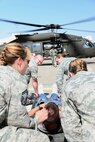Airmen prepare to lift a simulated casualty strapped to a medical litter during a Major Accident Response Exercise at Malmstrom Air Force Base, Mont., August 10, 2015. Airmen worked with the  Montana National Guard to medically transport simulated casualties by air using helicopters. (U.S. Air Force photo/Airman 1st Class Magen M. Reeves)