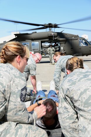 Airmen prepare to lift a simulated casualty strapped to a medical litter during a Major Accident Response Exercise at Malmstrom Air Force Base, Mont., August 10, 2015. Airmen worked with the  Montana National Guard to medically transport simulated casualties by air using helicopters. (U.S. Air Force photo/Airman 1st Class Magen M. Reeves)