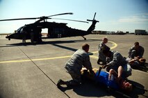 Airmen prepare to lift a simulated casualty strapped to a medical litter during a Major Accident Response Exercise at Malmstrom Air Force Base, Mont., August 10, 2015. Airmen worked together with the Montana National Guard to demonstrate response capabilities during a simulated natural disaster emergency where emergency medical airlifts are necessary.  (U.S. Air Force photo/Airman 1st Class Magen M. Reeves)
