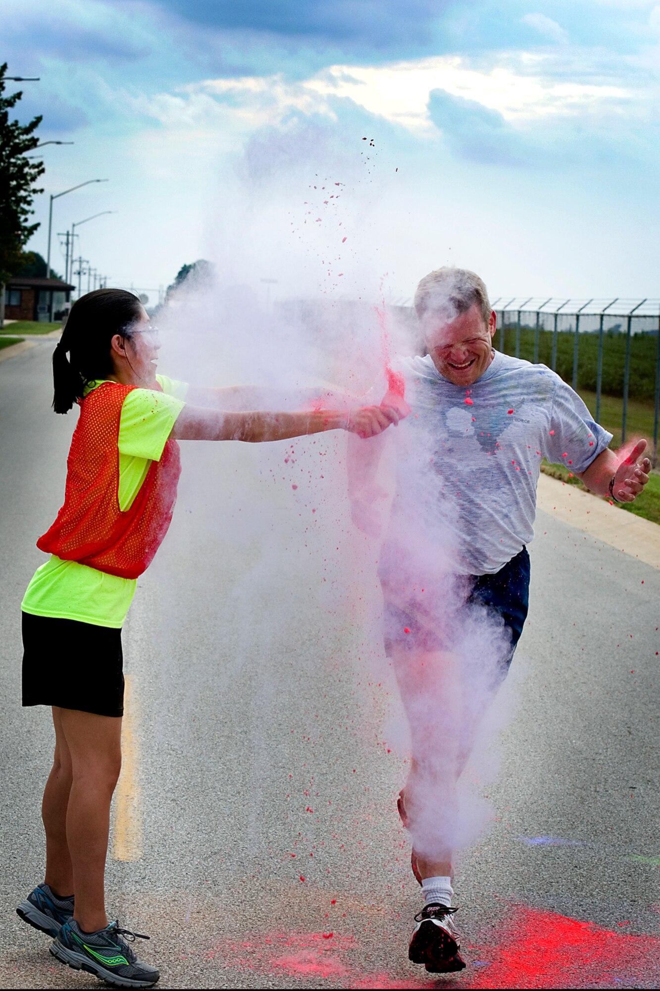 Hiram Gates, 434th Air Refueling Wing vice commander, gets dusted by a volunteer during a 5k color fun run held August 8, 2015 at Grissom Air Reserve Base, Ind. Eighteen runners faced high temperatures and volunteers set on dousing them with bright colored powder. (U.S. Air Force photo/Senior Airman Jami K. Lancette)