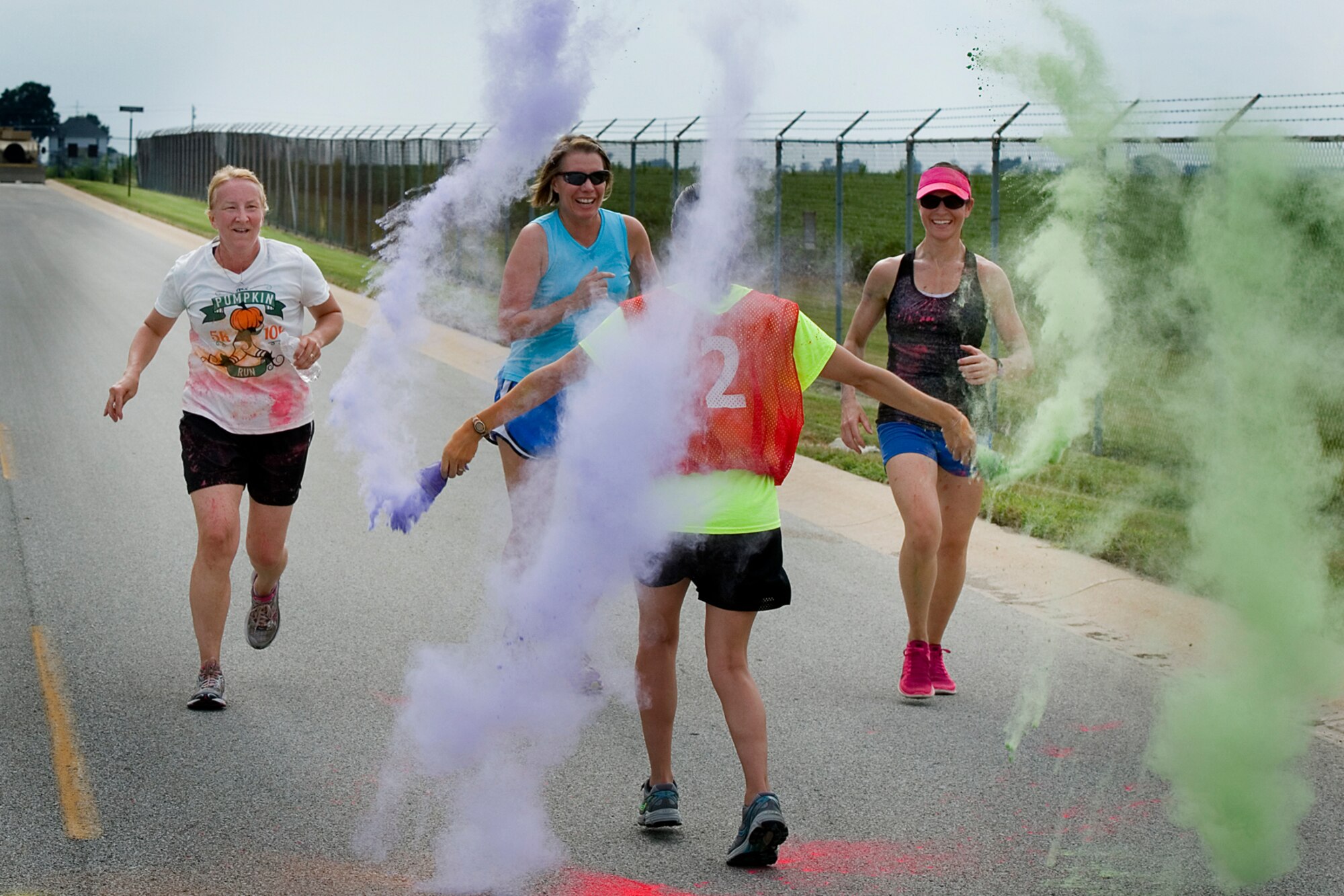 From left, Therese Kern, 434th Aerospace Medicine Squadron commander, Kathryn Russell, 434th Air Refueling Wing inspector general, and Wendi Conwell, 434th AMDS first sergeant, are all smiles as they get ready to run into a cloud of color during a 5k color fun run held August 8, 2015 at Grissom Air Reserve Base, Ind. Eighteen runners faced high temperatures and volunteers set on dousing them with bright colored powder. (U.S. Air Force photo/Senior Airman Jami K. Lancette)