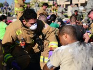 Airmen administer care to simulated natural disaster casualties during a Major Accident Response Exercise at Malmstrom Air Force Base, Mont., August 10, 2015. Airmen were evaluated in several emergency response sections to include building evacuations and Emergency Medical Technician procedures.  (U.S. Air Force photo/Airman 1st Class Magen M. Reeves)
