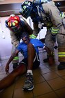 Airmen prepare to lift a simulated casualty during a Major Accident Response Exercise at Malmstrom Air Force Base, Mont., August 10, 2015. Airmen evacuated casualities during a simulated natural disaster and administered emergency health care. (U.S. Air Force photo/Airman 1st Class Magen M. Reeves)