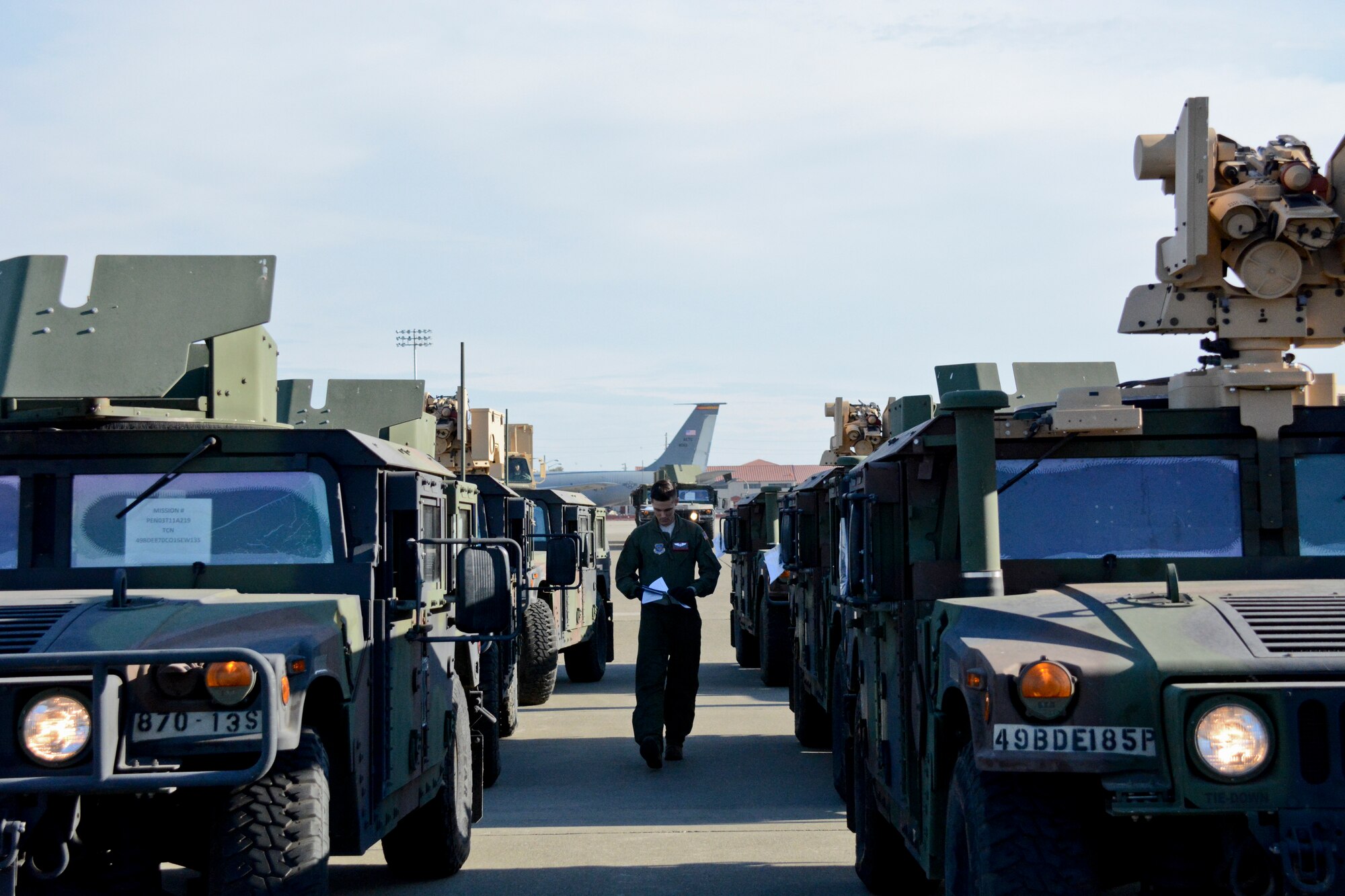 Senior Airman Robert Hamatake, 22nd Airlift Squadron loadmaster, inspects the Army Humvees Aug. 7 at Travis Air Force Base, California. The 22nd AS and the 821st Contingency Response Group assisted the 49th MP Brigade during Exercise Eagle Walk. (U.S. Air Force photo by Airman 1st Class Amber Carter) 