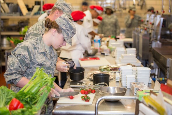 Airman 1st Class Stormie Geiger, 5th Force Support Squadron missile chef, cuts strawberries during the first Iron Chef Global Strike Challenge competition in the Jimmy Doolittle Center at Minot Air Force Base, N.D., Aug. 10, 2015. Three teams of three chefs from 5th FSS had one hour to complete their meals for the judges. (U.S. Air Force photo/ Airman 1st Class Justin T. Armstrong)

