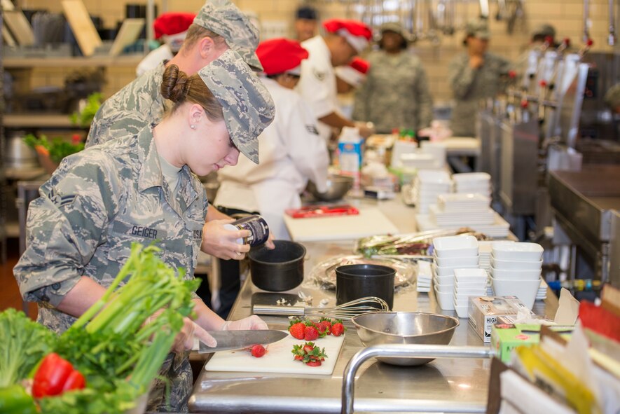 Airman 1st Class Stormie Geiger, 5th Force Support Squadron missile chef, cuts strawberries during the first Iron Chef Global Strike Challenge competition in the Jimmy Doolittle Center at Minot Air Force Base, N.D., Aug. 10, 2015. Three teams of three chefs from 5th FSS had one hour to complete their meals for the judges. (U.S. Air Force photo/ Airman 1st Class Justin T. Armstrong)

