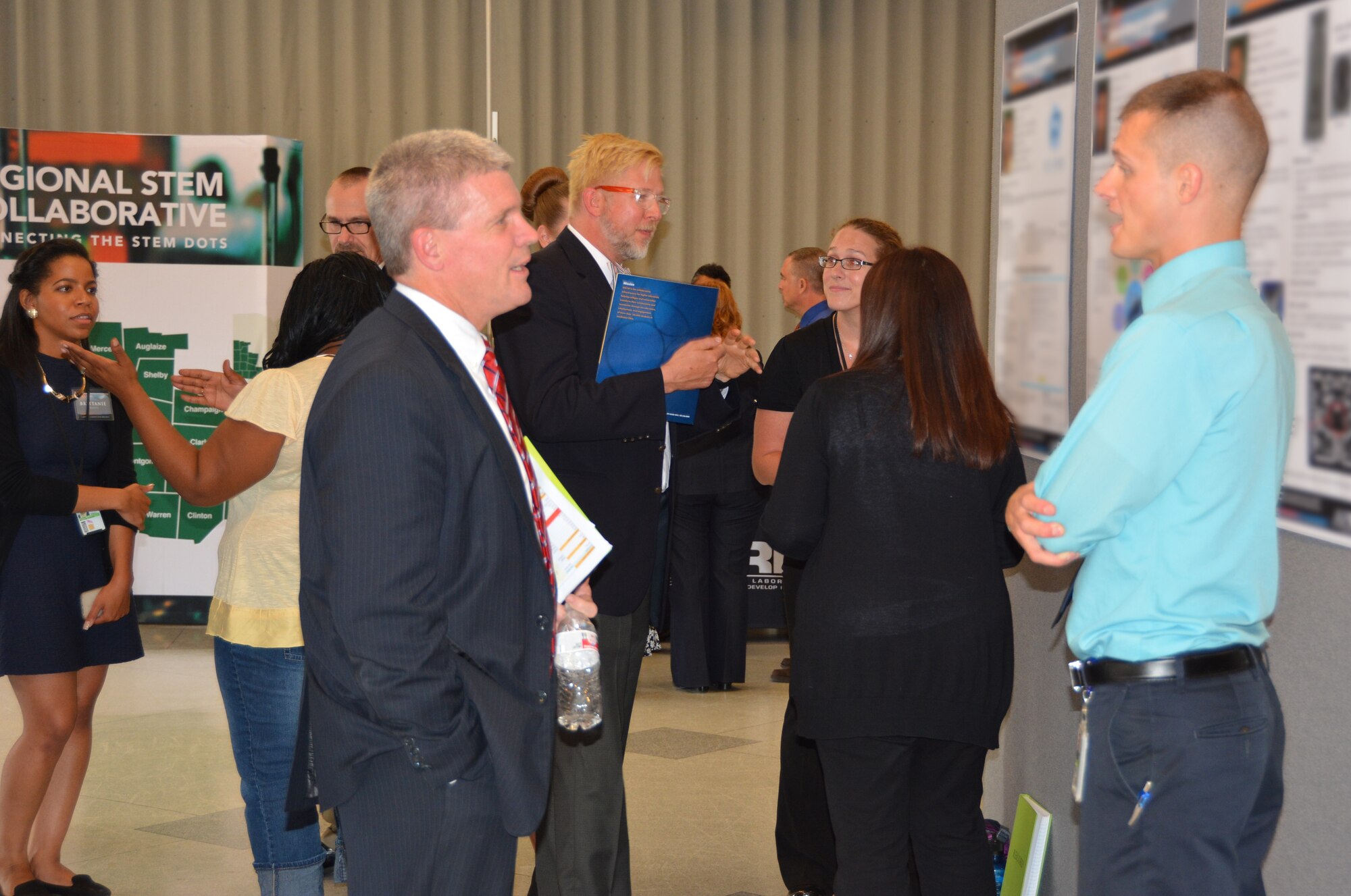 AFRL student research Brian Shivers (right) discusses his poster with Mr. Thomas Lockhart, Director of the AFRL Materials and Manufacturing Directorate, during the August 5 summer student poster session and tour.  (AFRL photo by Anise Simpson)