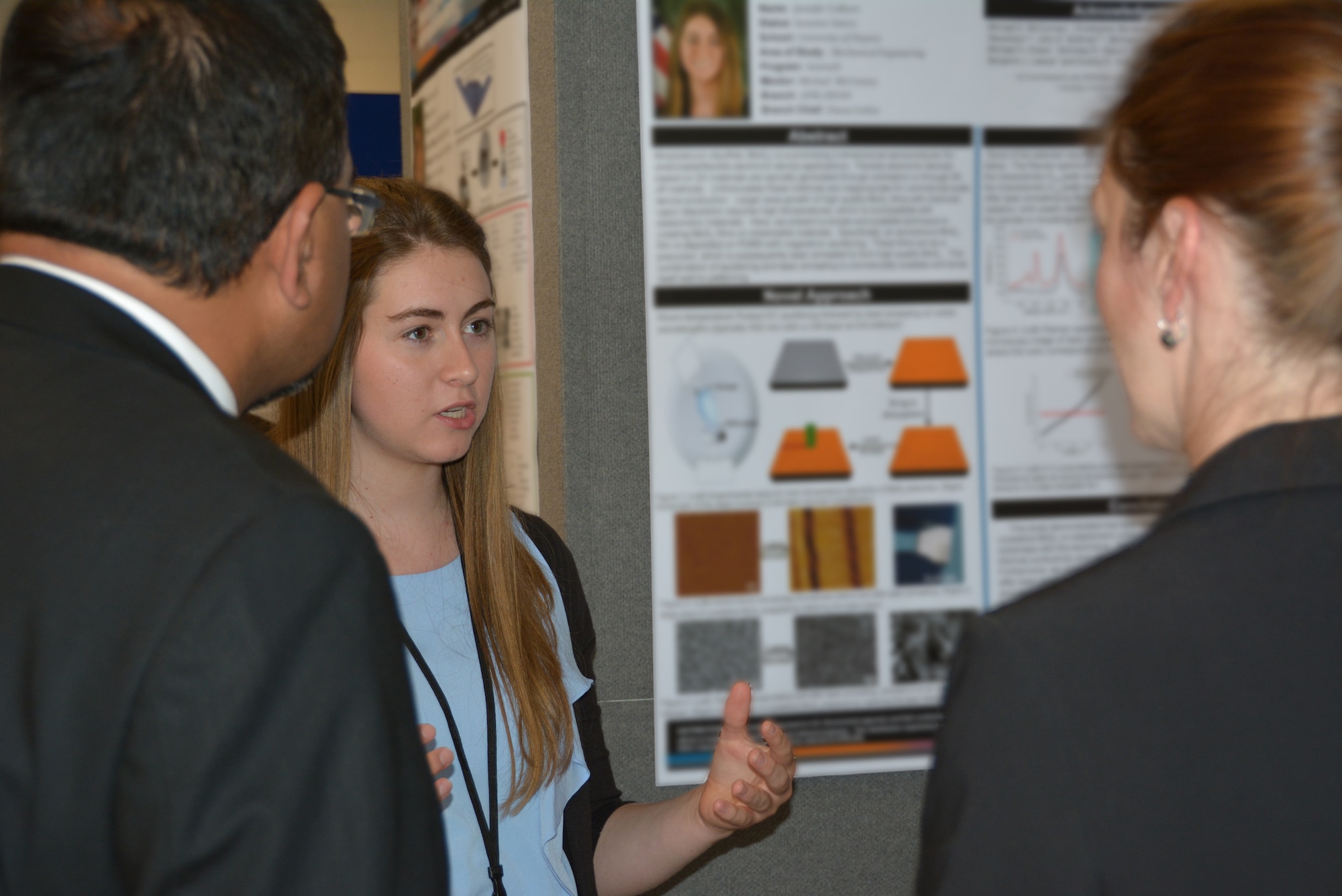 AFRL student researcher Ms. Jennifer Colborn describes her research to members of the Dayton Development Coalition during the August 5 summer student poster session and tour at the AFRL Materials and Manufacturing Directorate.  (AFRL photo by Anise Simpson)