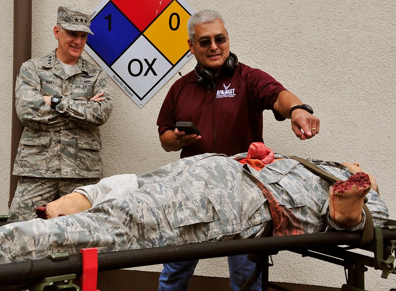 Lt. Gen. Timothy M. Ray, 3rd Air Force commander, watches as Carlos Rodriguez, 86th Medical Group simulation coordinator, demonstrates the capabilities of the realistic simulator dummies Aug. 4, 2015, at Ramstein Air Base, Germany. The simulators allow military members to train in realistic self-aid buddy care situations by releasing fake blood, making realistic movements and talking. (U.S. Air Force photo/Airman 1st Class Larissa Greatwood)