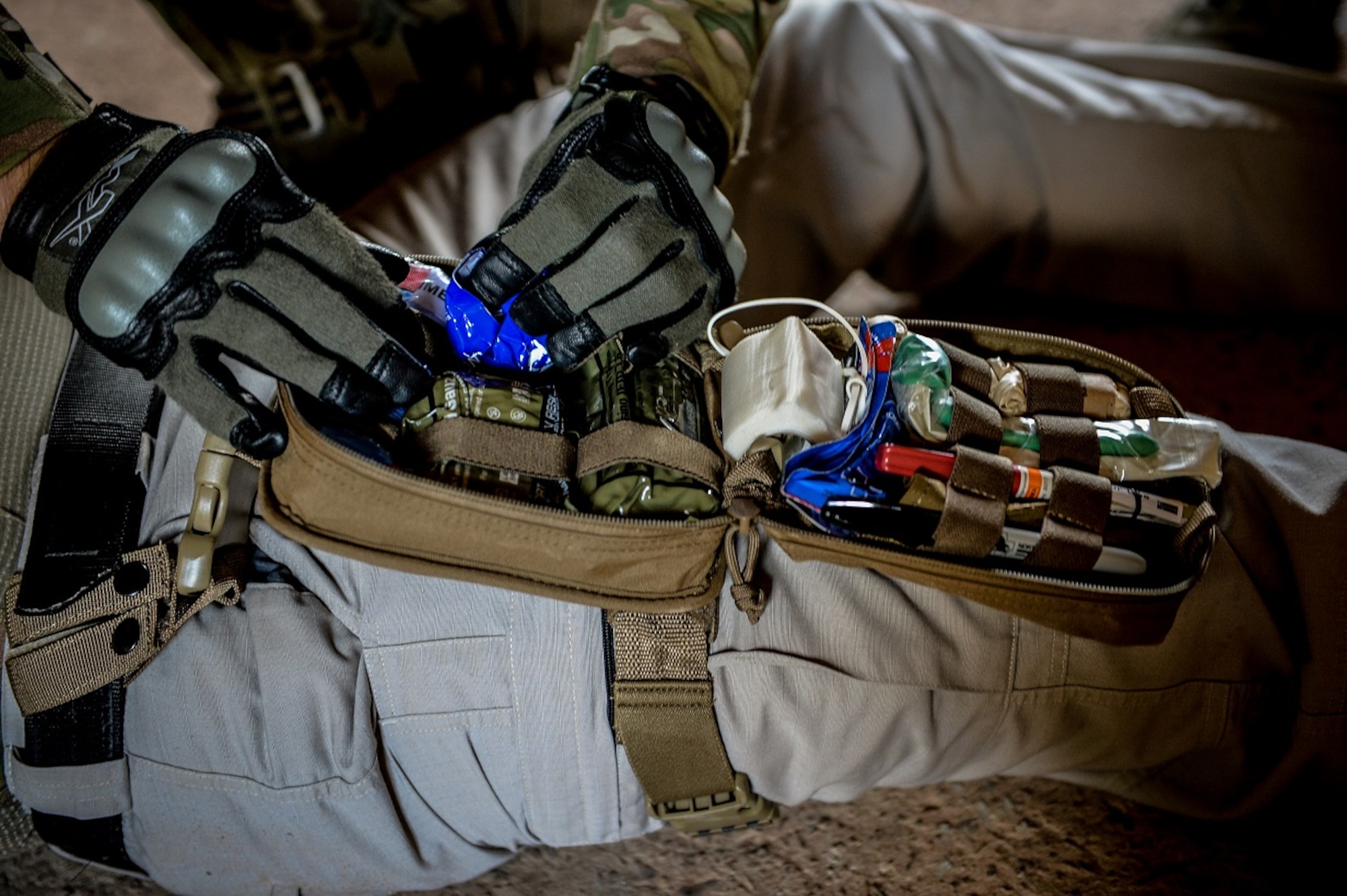 A first responder retrieves gauze from a first-aid kit to treat a simulated wound during the Tactical Combat Casualty Care course Aug. 5, 2015, on Baumholder, Germany. The four-day course was comprised of two classroom days and two days in the field, where participants were tested on the skills they learned. (U.S. Air Force photo/Senior Airman Nicole Sikorski)
