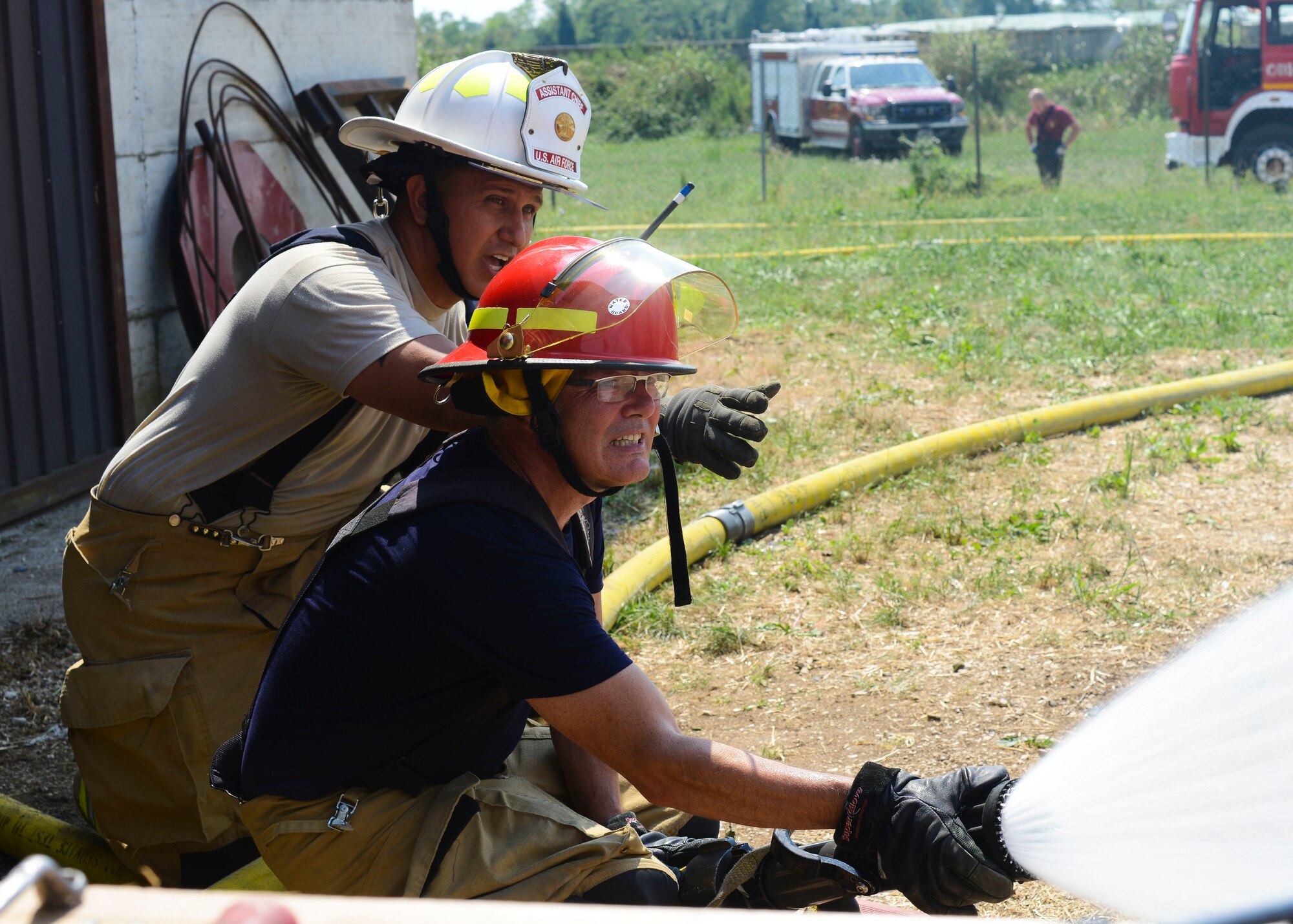 U.S. Air Force Master Sgt. Angus Adolpho, 31st Civil Engineer Squadron assistant fire chief, and Daniele Didoni, 31 CES firefighter, battle a hay barn fire, Aug. 11, 2015, near Marsure, Italy. Aviano Air Base personnel responded to the emergency with a medical vehicle and two fire trucks. (U.S. Air Force photo by Senior Airman Austin Harvill/Released)