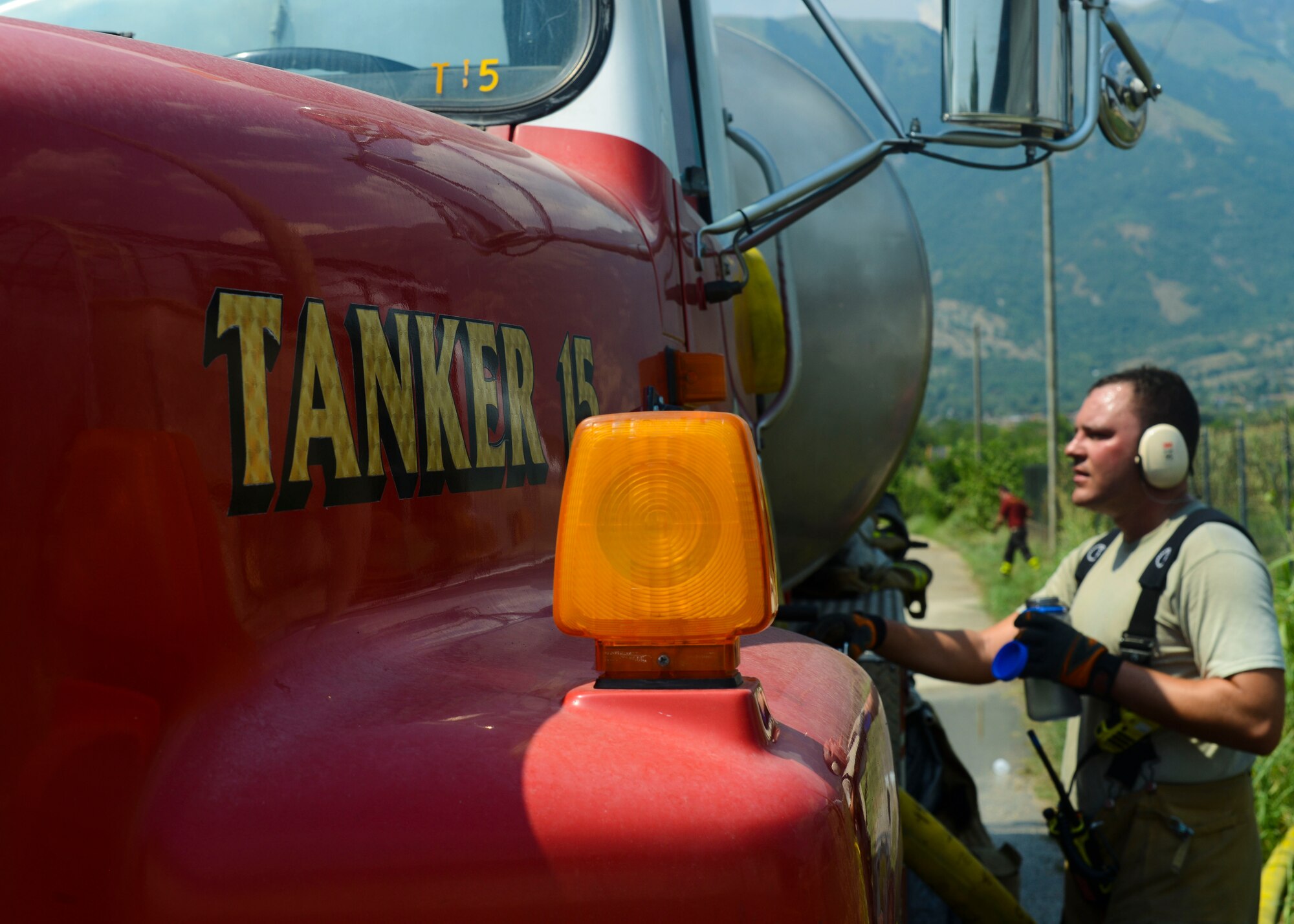 U.S. Air Force TSgt Ryan Day, 31st Civil Engineer Squadron firefighter, adjusts water pressure to battle a hay barn fire, Aug. 11, 2015, near Marsure, Italy. At the request of local Italian authorities, Aviano Air Base personnel responded to the off-base fire due to their proximity to Marsure. (U.S. Air Force photo by Senior Airman Austin Harvill/Released)
