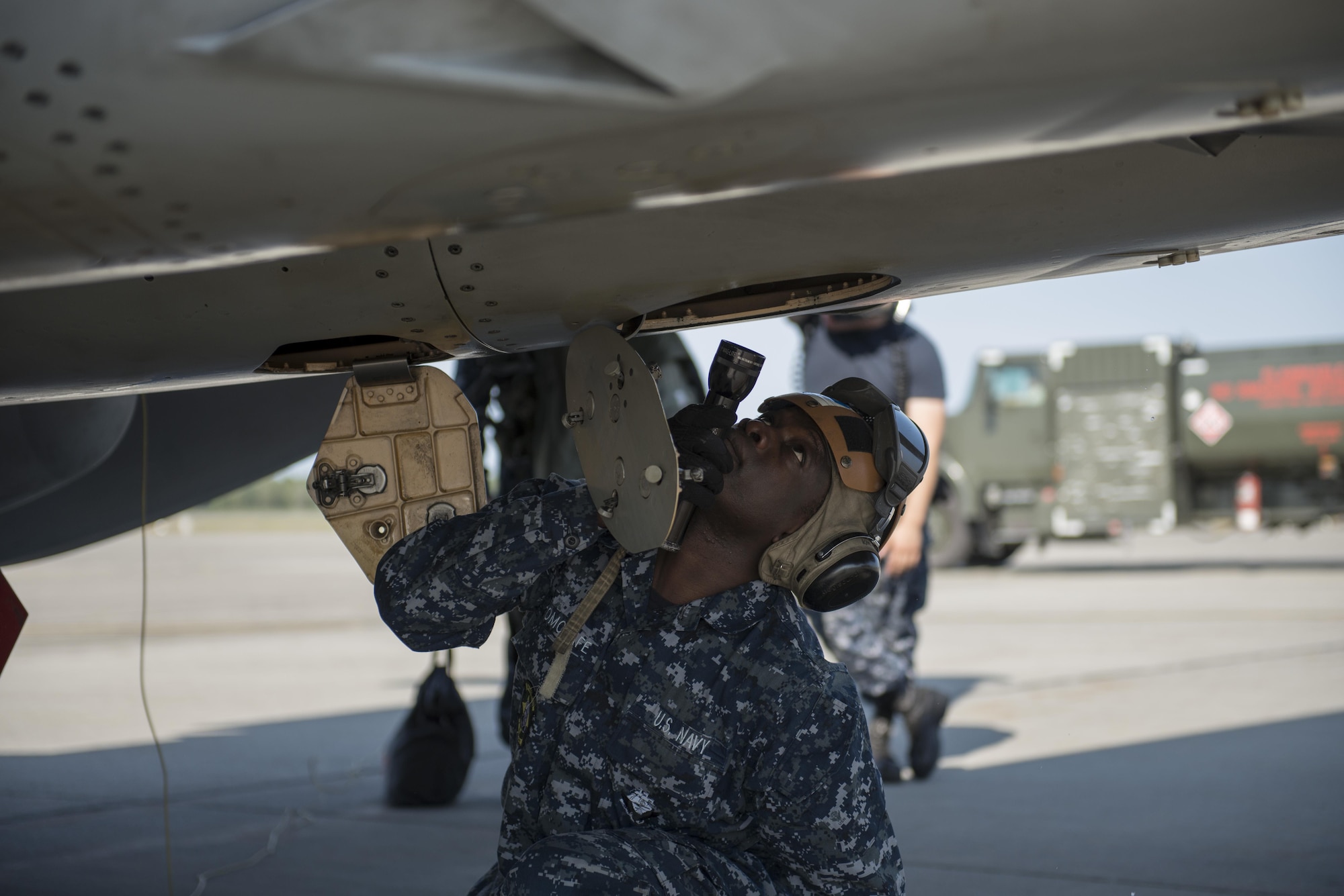 U.S. Navy Airman Samuel Akomolafe, a plane captain trainee assigned to Electronic Attack Squadron 209, Naval Air Station Whidbey Island, Wash., inspects an EA-18G Growler electronic warfare aircraft, Aug. 7, 2015, following a RED FLAG-Alaska (RF-A) 15-3 sortie to ensure the jet maintains operational readiness at Eielson Air Force Base, Alaska. RF-A is a Pacific Air Forces commander-directed field training exercise for U.S. and partner nation forces, providing combined offensive counter-air, interdiction, close air support and large force employment training in a simulated combat environment. (U.S. Air Force photo by 1Lt Elias Zani/Released)