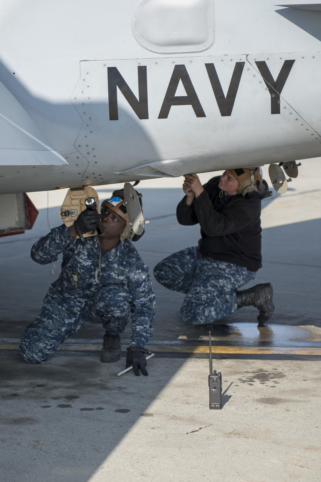 U.S. Navy Air Controlman First Class Cameron French, a leading petty officer, and Airman Samuel Akomolafe, a plane captain trainee, both assigned to Electronic Attack Squadron 209, Naval Air Station Whidbey Island, Wash., inspect an EA-18G Growler electronic warfare aircraft, Aug. 7, 2015, following a RED FLAG-Alaska (RF-A) 15-3 sortie to ensure the jet maintains operational readiness at Eielson Air Force Base, Alaska. RF-A is a Pacific Air Forces commander-directed field training exercise for U.S. and partner nation forces, providing combined offensive counter-air, interdiction, close air support and large force employment training in a simulated combat environment. (U.S. Air Force photo by 1Lt Elias Zani/Released)