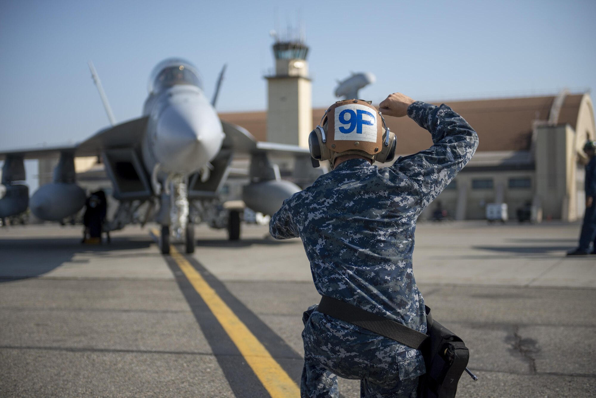 U.S. Navy Airman Monty Lowden, a plane captain assigned to Electronic Attack Squadron 209, Naval Air Station Whidbey Island, Wash., assists in the parking of an EA-18G Growler electronic warfare aircraft, Aug. 7, 2015, following a RED FLAG-Alaska (RF-A) 15-3 sortie at Eielson Air Force Base, Alaska. RF-A is a Pacific Air Forces commander-directed field training exercise for U.S. and partner nation forces, providing combined offensive counter-air, interdiction, close air support and large force employment training in a simulated combat environment. (U.S. Air Force photo by 1Lt Elias Zani/Released)