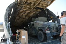 Airmen assist Soldiers Aug. 7 at Travis Air Force Base, California. Loadmasters and aerial porters from Travis helped Army military police load their vehicles on to a Travis C-5M Super Galaxy. (U.S. Air Force photo by Airman 1st Class Amber Carter) 
