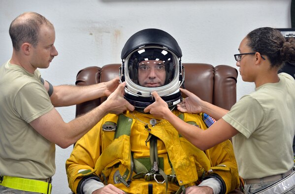 Senior Airman Garrett and Airman 1stClass Christian, both are expeditionary reconnaissance squadron physiology support technicians, assist Lt. Col. David, an ERS U-2S pilot, with donning a full-pressure suit at an undisclosed location in Southwest Asia, Aug. 7, 2015. U-2 pilots are required to wear the specialized suit due to the high altitudes they typically fly at. The physiological support detachment team is responsible for maintaining the suit, ensuring it functions properly and assisting pilots with donning the gear. (U.S. Air Force photo/Tech. Sgt. Jeff Andrejcik)