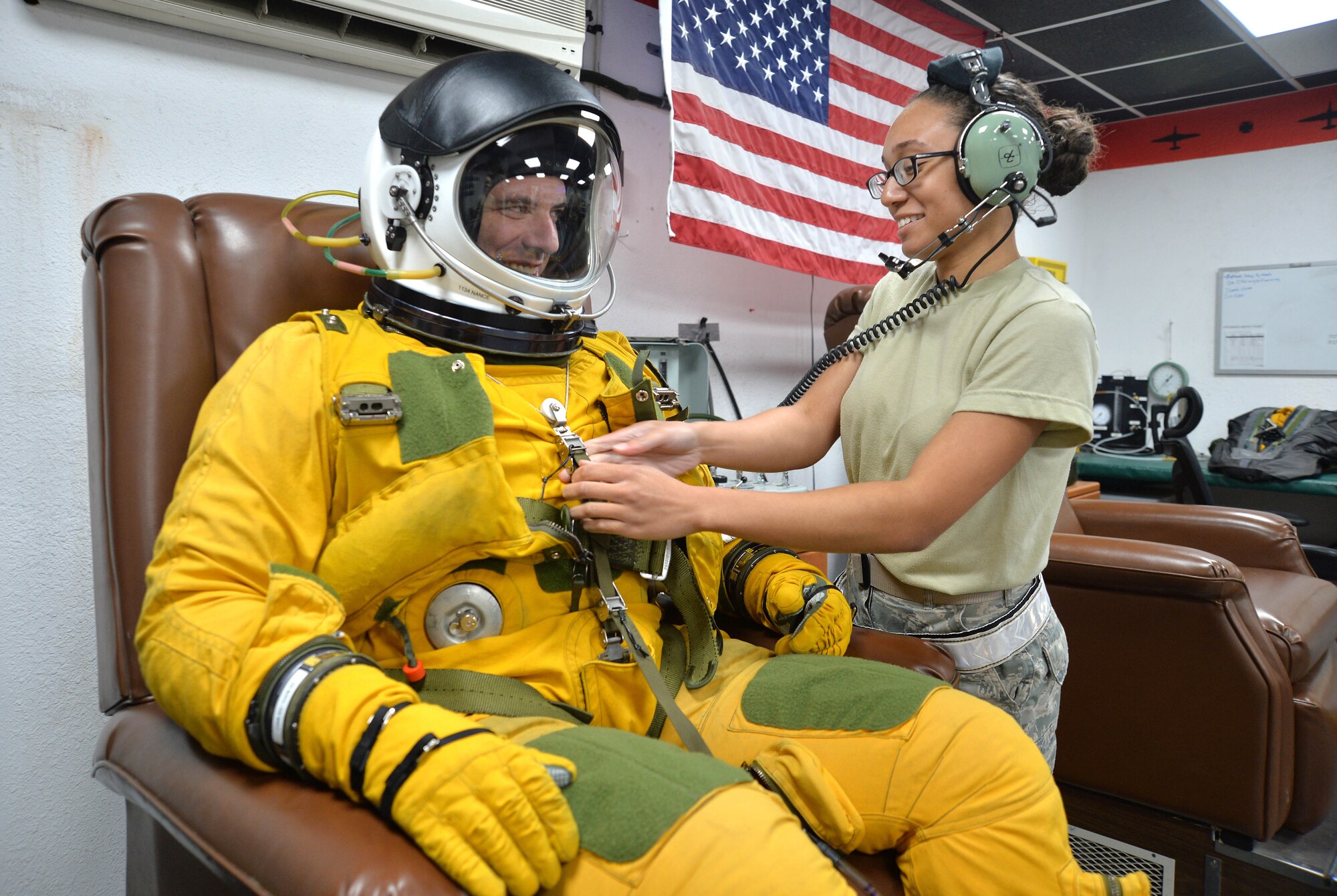 Airman First Class Christian, Expeditionary Reconnaissance Squadron physiology support technician, right, shares a laugh with Lt. Col. David, ERS U-2 pilot, during the pressurizing process at an undisclosed location in Southwest Asia Aug. 7, 2015. U-2 pilots are required to wear the specialized suit due to the high altitudes they typically fly at. The physiological support detachment team is responsible for maintaining the suit, ensuring it functions properly and assisting pilots with donning the gear. (U.S. Air Force photo/Tech. Sgt. Jeff Andrejcik)