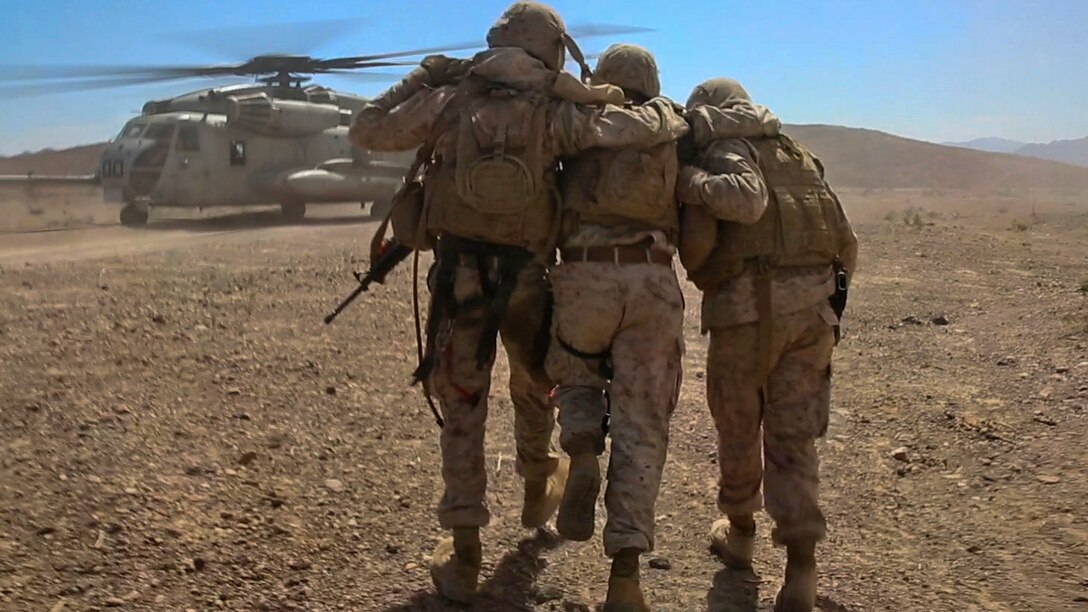 Marines with Combat Logistics Battalion 1, Combat Logistics Regiment 1, 1st Marine Logistics Group, help a simulated casualty to a CH-53E Super Stallion during a casualty evacuation drill at Marine Corps Air Ground Combat Center Twentynine Palms, California, Aug. 10, 2015. A simulated improvised explosive device attack left the Marines with a disabled vehicle and two wounded Marines awaiting evacuation by helicopter.