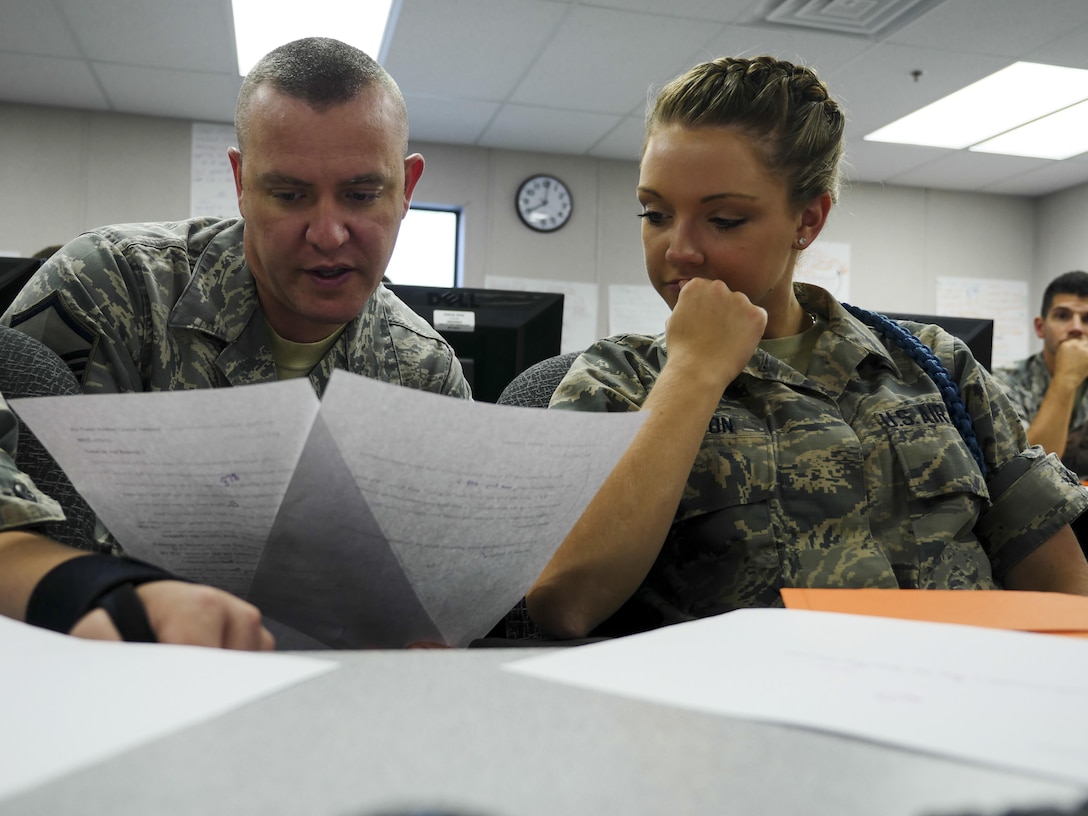 Air Force Master Sgt. Michael Andriacco, Basic Photojournalist Course-Air Force instructor, answers a question from Airman Basic Lauren M. Johnson, BPJC-USAF Class 050-15 student, about a writing assignment at the Defense Information School, Fort George G. Meade, Md., Aug. 6, 2015. BPJC-USAF provides instruction in command information, community engagement, media relations, new writing and basic still photography. (DoD photo by Joseph Coslett/Released)