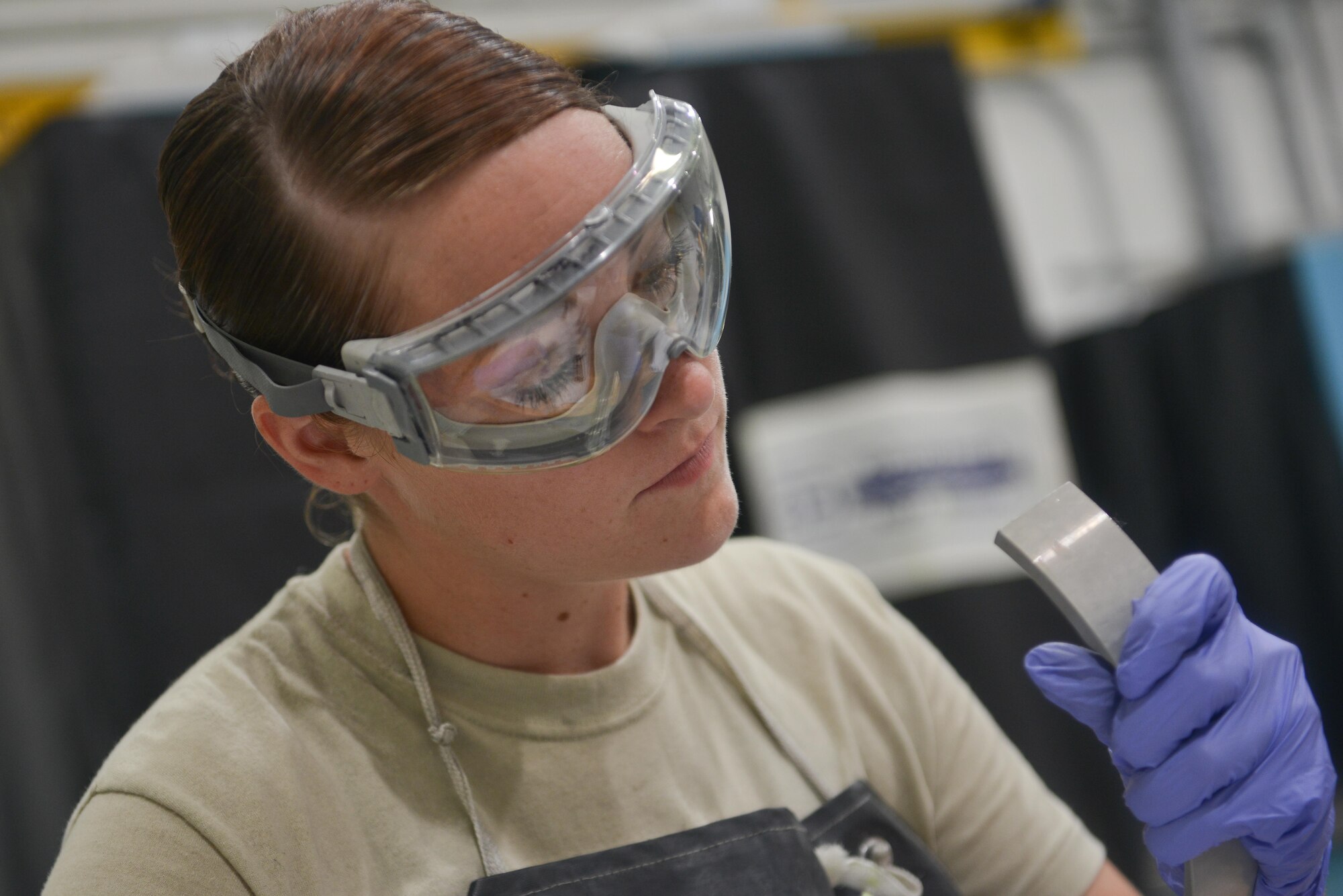 Airmen 1st Class Amber Burns, 379th Expeditionary Maintenance Squadron Nondestructive Inspection laboratory, inspects a brake part from an F-16 Fighting Falcon for visible cracks or wear August 12, 2015 at Al Udeid Air Base, Qatar. NDI Airmen inspect for cracks and flaws on aircraft and their components, aerospace ground equipment and safety equipment.  They also test jet engine oil samples, using a variety of methods, like magnetic particle, fluorescent penetrant, eddy current, radiography, optical and ultrasonic equipment. (U.S. Air Force photo/Staff Sgt. Alexandre Montes)   