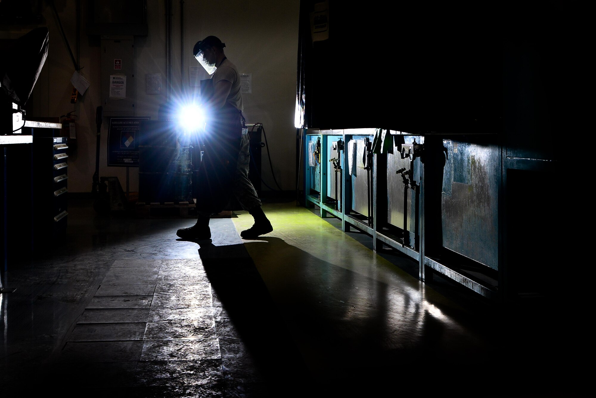 Airman 1st Class Berkeley Lopez, 379th Expeditionary Maintenance Squadron Nondestructive Inspection laboratory, leaves the inspection area after coating brake parts in fluorescent liquid penetrant to let them soak for 30 minutes before the inspection process August 12, 2015 at Al Udeid Air Base, Qatar. NDI Airmen inspect for cracks and flaws on aircraft and their components, aerospace ground equipment and safety equipment.  They also test jet engine oil samples, using a variety of methods, like magnetic particle, fluorescent penetrant, eddy current, radiography, optical and ultrasonic equipment. (U.S. Air Force photo/Staff Sgt. Alexandre Montes)   