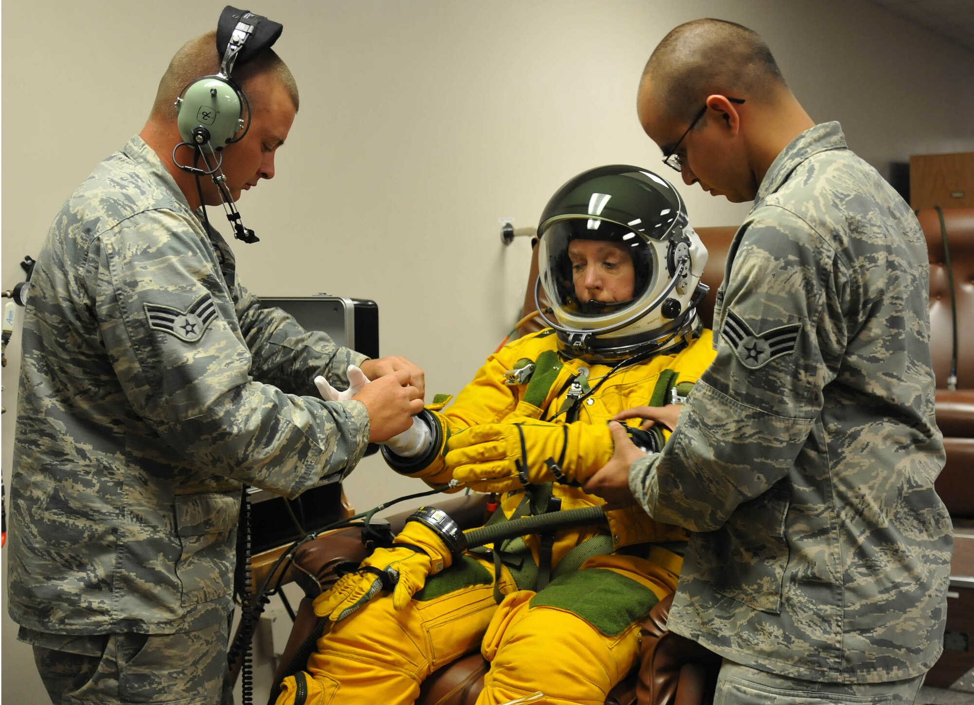 Senior Airmen Aaron Saenz and Kyle Lang, 9th Physiological Support Squadron launch and recovery technicians, help Secretary of the Air Force Deborah Lee James properly dress in a high-altitude pressure suit at Beale Air Force Base, Calif., Aug. 11, 2015. The specialized pressure suit allows U-2S pilots to safely fly at altitudes reaching 70,000 feet. James visited Beale AFB to receive a first-hand perspective of high-altitude intelligence, surveillance and reconnaissance from collection to dissemination. (U.S. Air Force photo/Senior Airman Dana J. Cable)