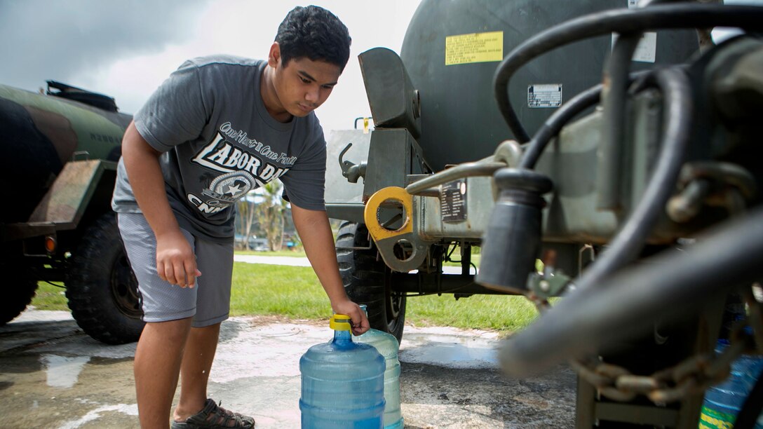 A local man fills up a water jug at a water distribution site set up by U.S. Marines from Combat Logistics Battalion 31, 31st Marin Expeditionary  Unit, as part of typhoon relief efforts in Saipan, Aug. 11, 2015. The 31st MEU and the ships of the Bonhomme Richard Amphibious Ready Group are assisting the Federal Emergency Management Agency with distributing emergency relief supplies to Saipan after the island was struck by Typhoon Soudelor Aug. 2-3.