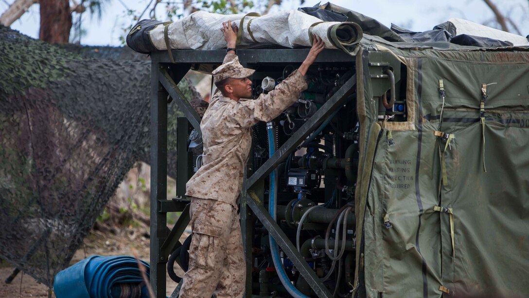 U.S. Marine Lance Cpl. Harley Sifflet, with Combat Logistics Battalion 31, 31st Marine Expeditionary Unit, prepares a Tactical Water Purification System to distribute water to local civilians as part of typhoon relief efforts in Saipan, Aug. 11, 2015. The 31st MEU and the ships of the Bonhomme Richard Amphibious Ready Group are assisting the Federal Emergency Management Agency with distributing emergency relief supplies to Saipan after the island was struck by Typhoon Soudelor Aug. 2-3.