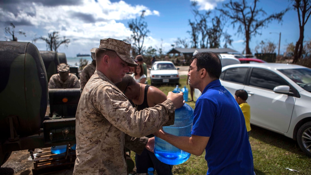 U.S. Marines with Combat Logistics Battalion 31, 31st Marine Expeditionary Unit, distribute water to local civilians during typhoon relief efforts in Saipan, Aug. 11, 2015. The 31st MEU and the ships of the Bonhomme Richard Amphibious Ready Group are assisting the Federal Emergency Management Agency with distributing emergency relief supplies to Saipan after the island was struck by Typhoon Soudelor Aug. 2-3.