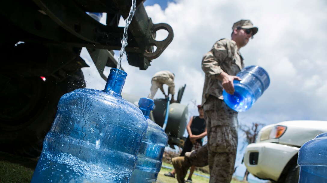 U.S. Marines with Combat Logistics Battalion 31, 31st Marine Expeditionary Unit, distribute water to local civilians as part of typhoon relief efforts in Saipan, Aug. 12, 2015. The 31st MEU and the ships of the Bonhomme Richard Amphibious Ready Group are assisting the Federal Emergency Management Agency with distributing emergency relief supplies to Saipan after the island was struck by Typhoon Soudelor Aug. 2-3.