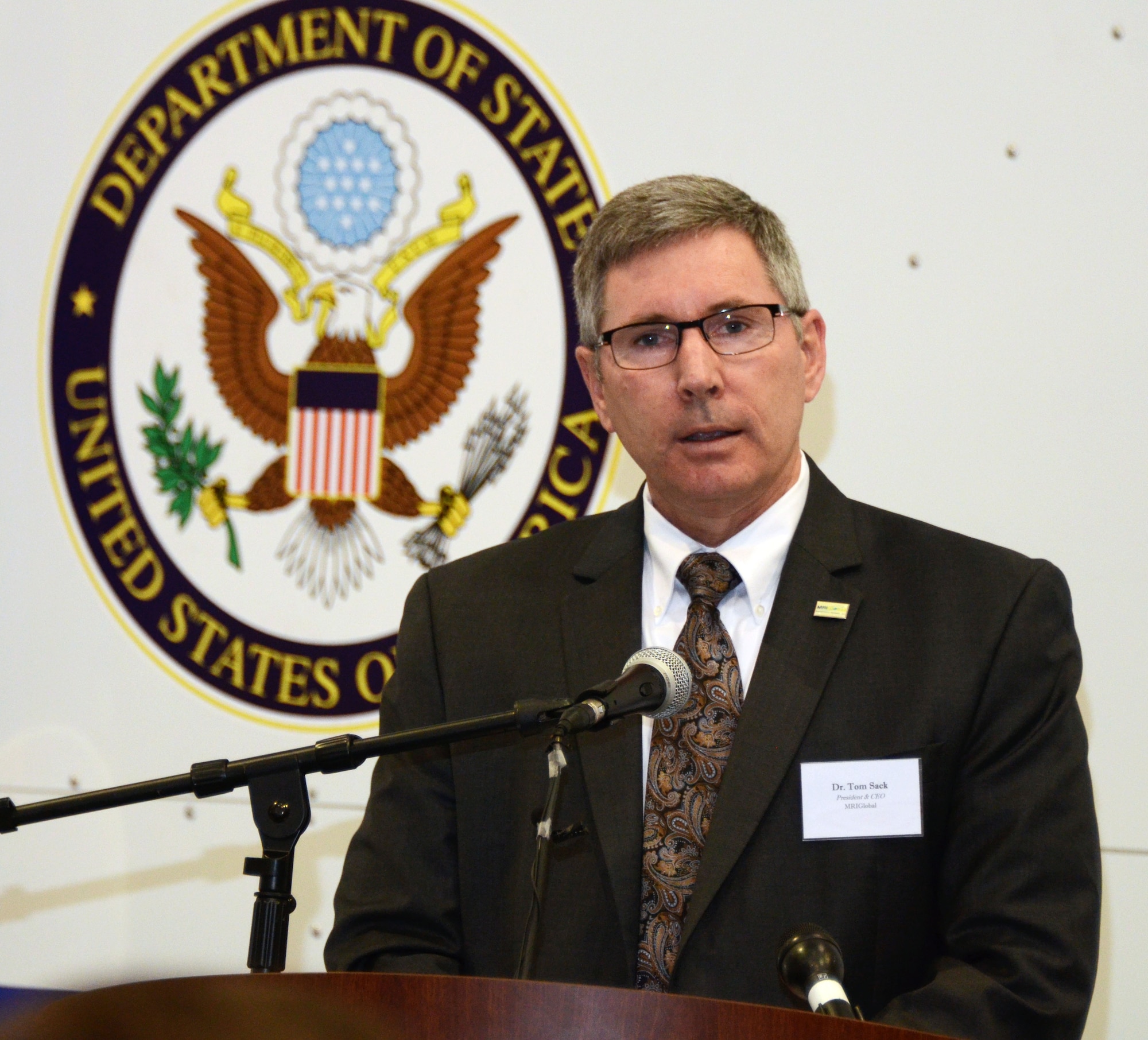 Dr. Tom Sack, President and CEO of MRI Global, addresses an audience of personnel from the Department of State, MRI Global, Paul Allen Foundation and members of the 94th Airlift Wing, at an unveiling of the DOS Containerized Biocontainment System held at Dobbins Air Reserve Base, Ga. Aug. 11, 2015. (U.S. Air Force photo/Don Peek)