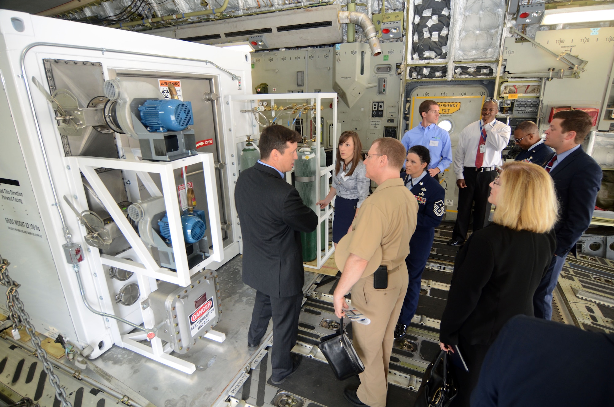 Congressional staff members receive a tour through one of two of the DOS Containerized Biocontainment Systems presented at an unveiling ceremony held at Dobbins Air Reserve Base, Ga. Aug. 11, 2015. The CBCS was loaded onto a C-17 cargo aircraft to demonstrate airlift capability. (U.S. Air Force photo/Don Peek)