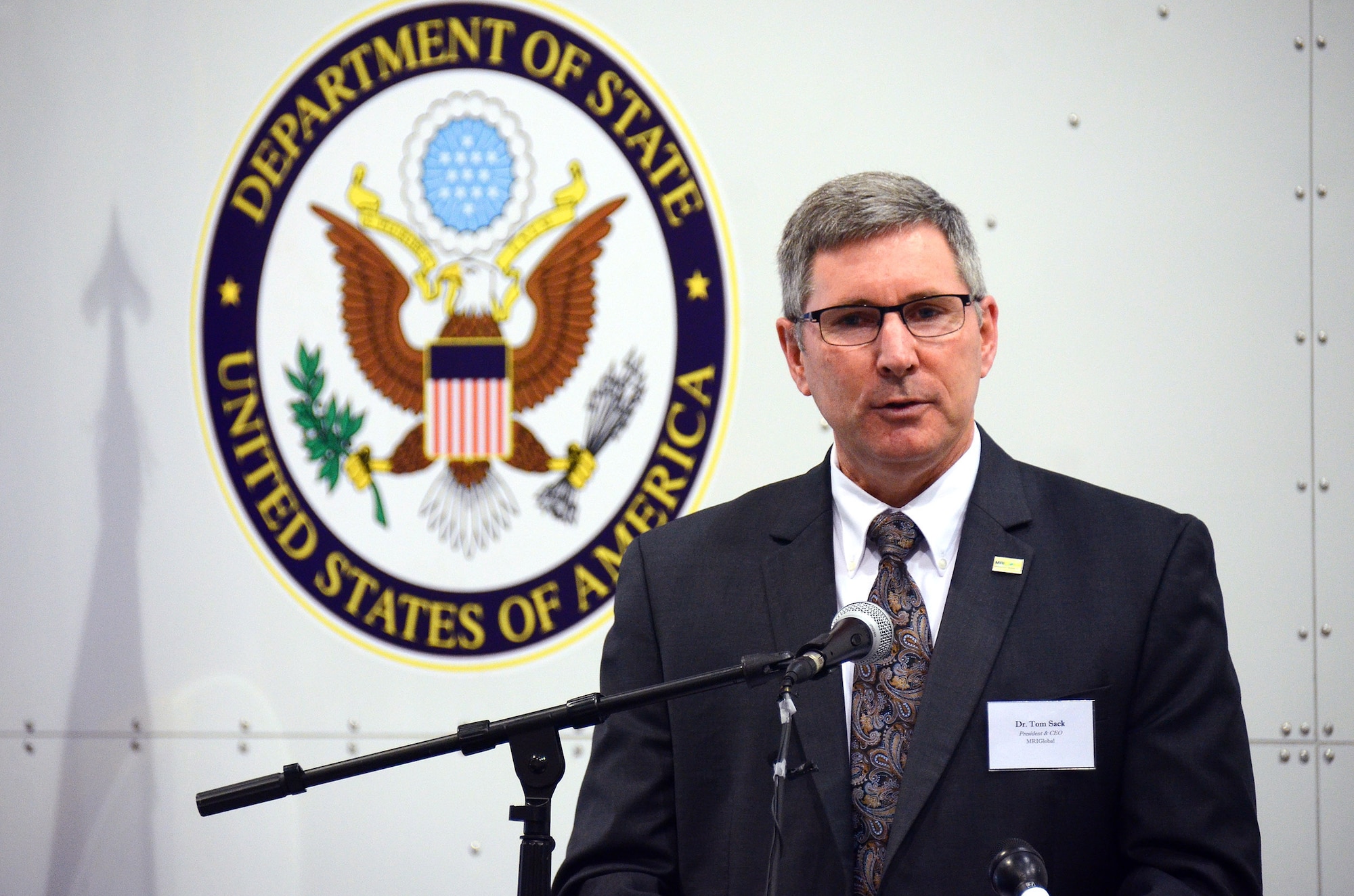Dr. Tom Sack, president and chief executive officer MRIGlobal, gives remarks at the unveiling of the US State Department sponsored Containerized Biocontainment Systems units at Dobbins Air Reserve Base, Ga., Aug. 11, 2015. The two Containerized Biocontainment units built by MRIGlobal through a partnership with the U.S. State Dept. and the Paul G. Allen Ebola Program, will be positioned at Dobbins ARB, ready for future. (U.S. Air Force photo/ Brad Fallin)