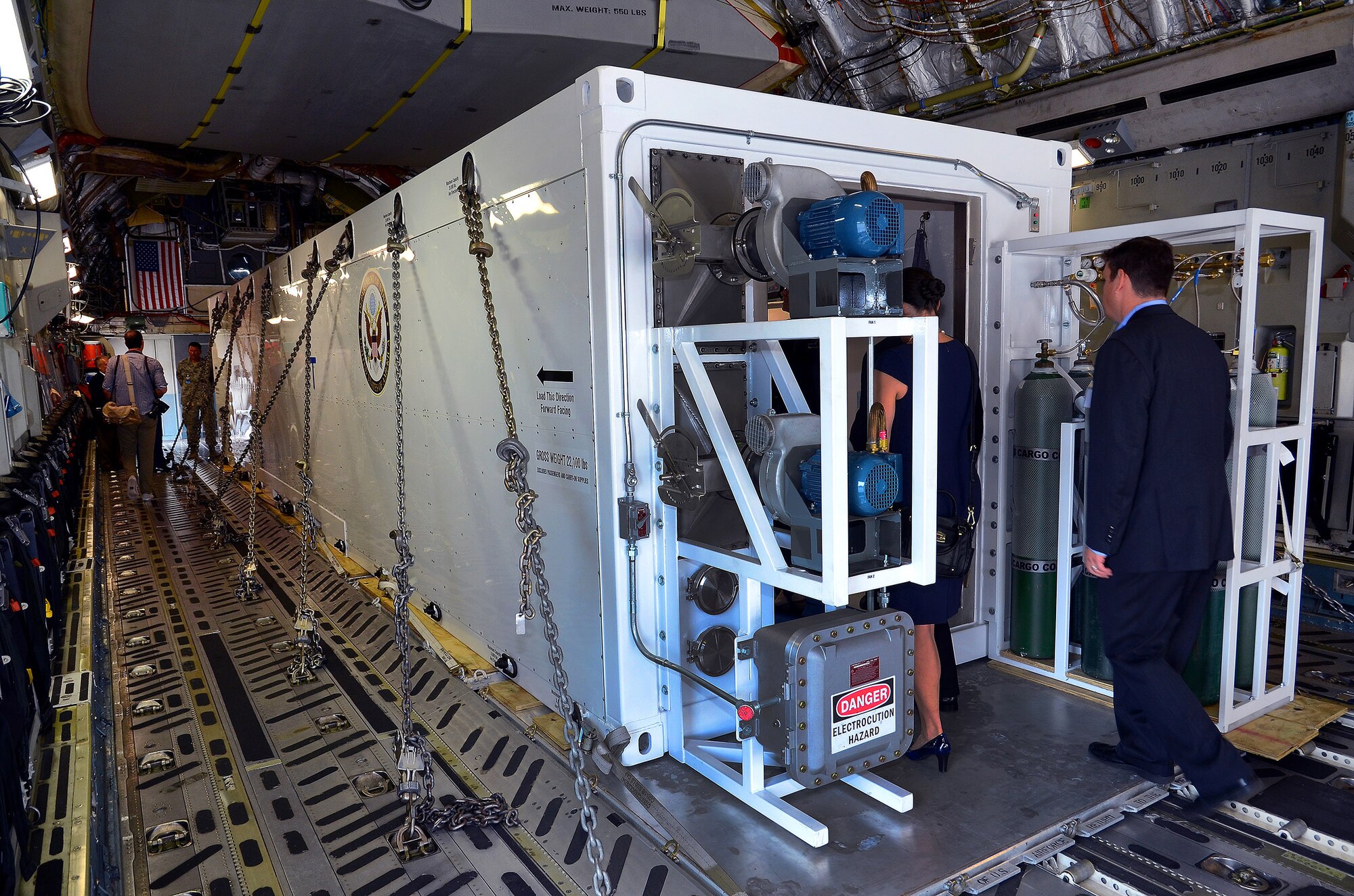 Invited guest and members of the press tour the second Containerized Biocontainment Systems unit positioned on a U.S. Air Force C-17 to see how the unit could be airlifted to anywhere in the world if needed; Dobbins Air Reserve Base, Ga., Aug. 11, 2015. The two Containerized Biocontainment units built by MRIGlobal through a partnership with the U.S. State Dept. and the Paul G. Allen Ebola Program, will be positioned at Dobbins ARB, ready for future. (U.S. Air Force photo/ Brad Fallin)