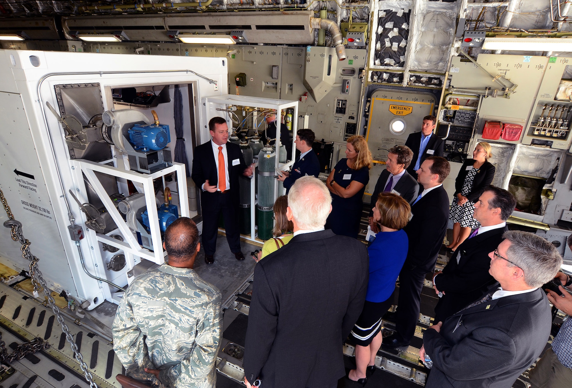 Invited guest and members of the press receive a briefing from U.S. State Department Director of Operational Medicine Dr. Will Walters about the Containerized Biocontainment Systems unit positioned on a U.S. Air Force C-17 to see how the unit could be airlifted to anywhere in the world if needed; Dobbins Air Reserve Base, Ga., Aug. 11, 2015. The two Containerized Biocontainment units were built by MRIGlobal through a partnership with the U.S. State Dept. and the Paul G. Allen Ebola Program, will be positioned at Dobbins ARB, ready for future. (U.S. Air Force photo/ Brad Fallin)